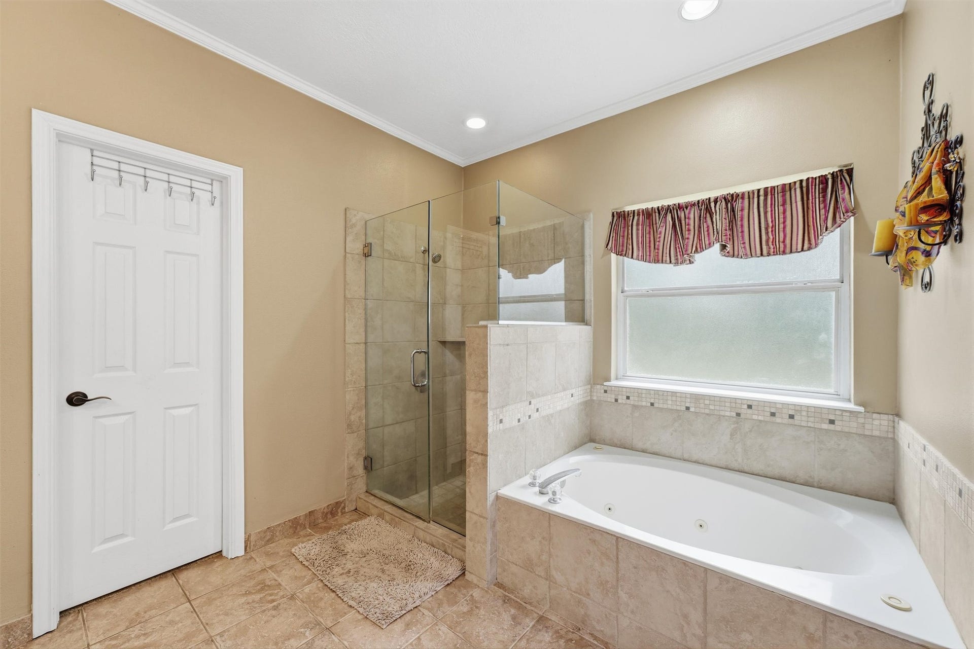 The primary bathroom showcases a large jetted soaking tub and separate shower. Perfect place to relax and unwind after a long day.