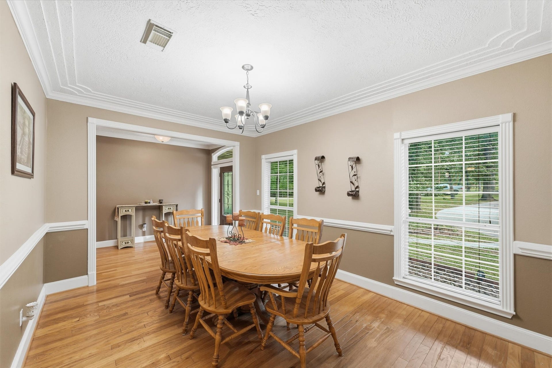 Spacious dining room featuring beautiful hard wood floors, elegant molding and classic chair rail detailing.