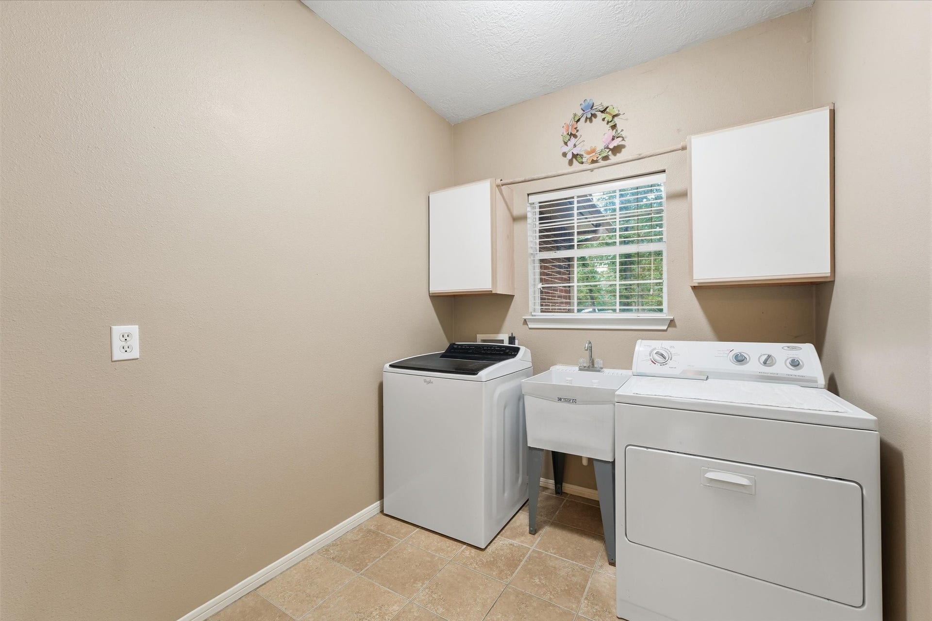 Large laundry room has plenty of space to tackle everyday laundry needs with ease an convenience.