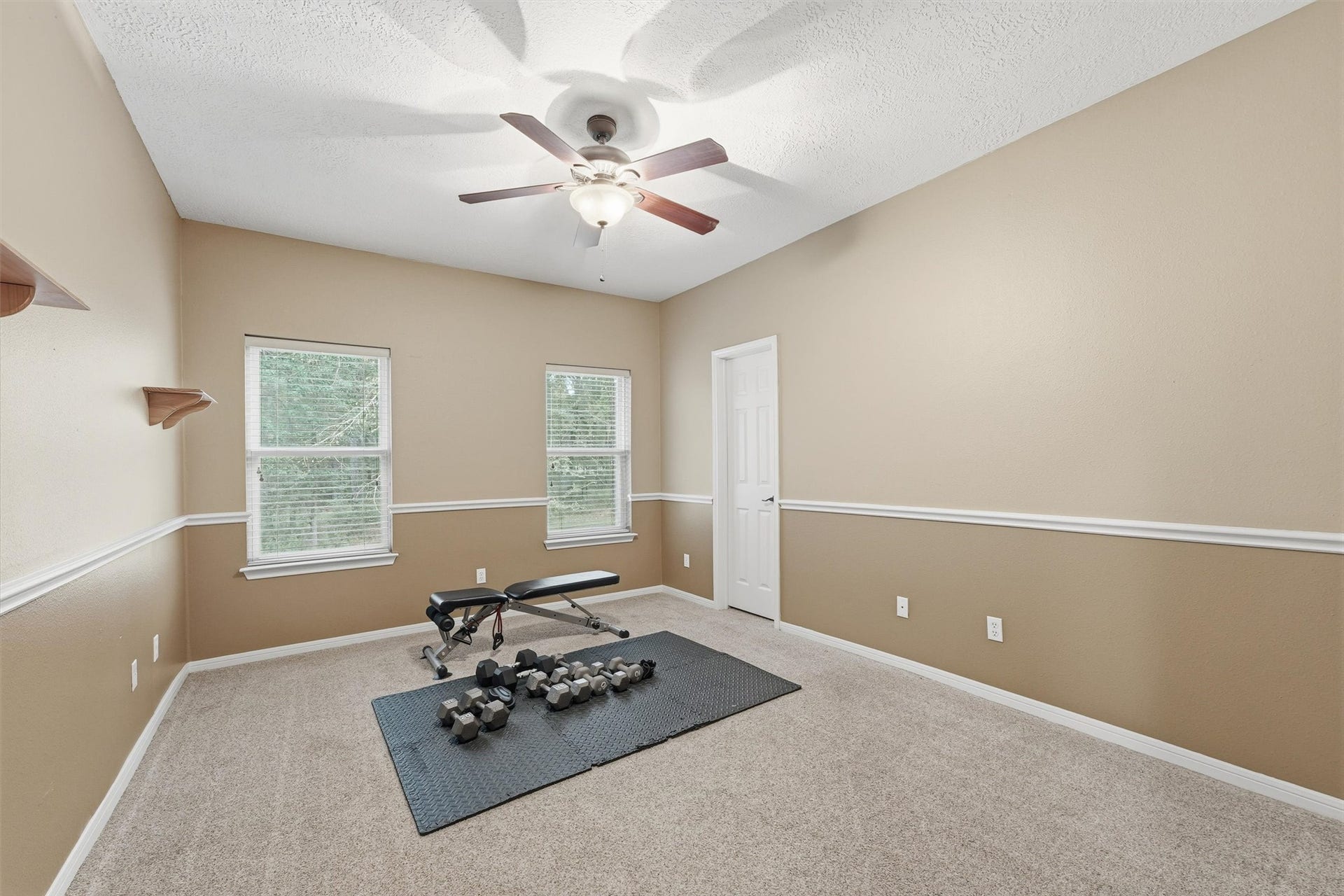 This bedroom can also be used for a study or as seen here a workout room.