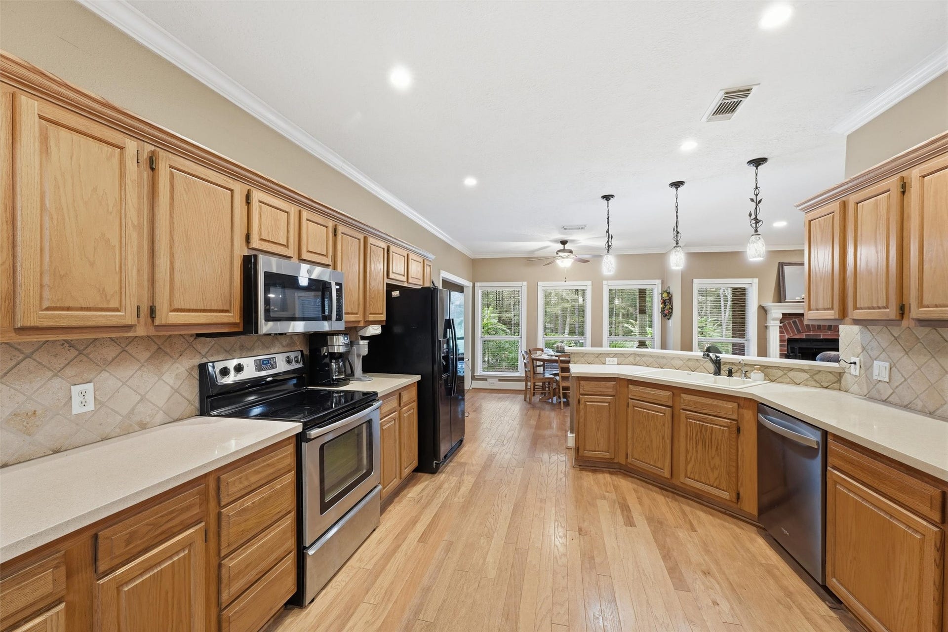 Bright and inviting kitchen featuring abundant cabinetry for storage and plenty of lighting.