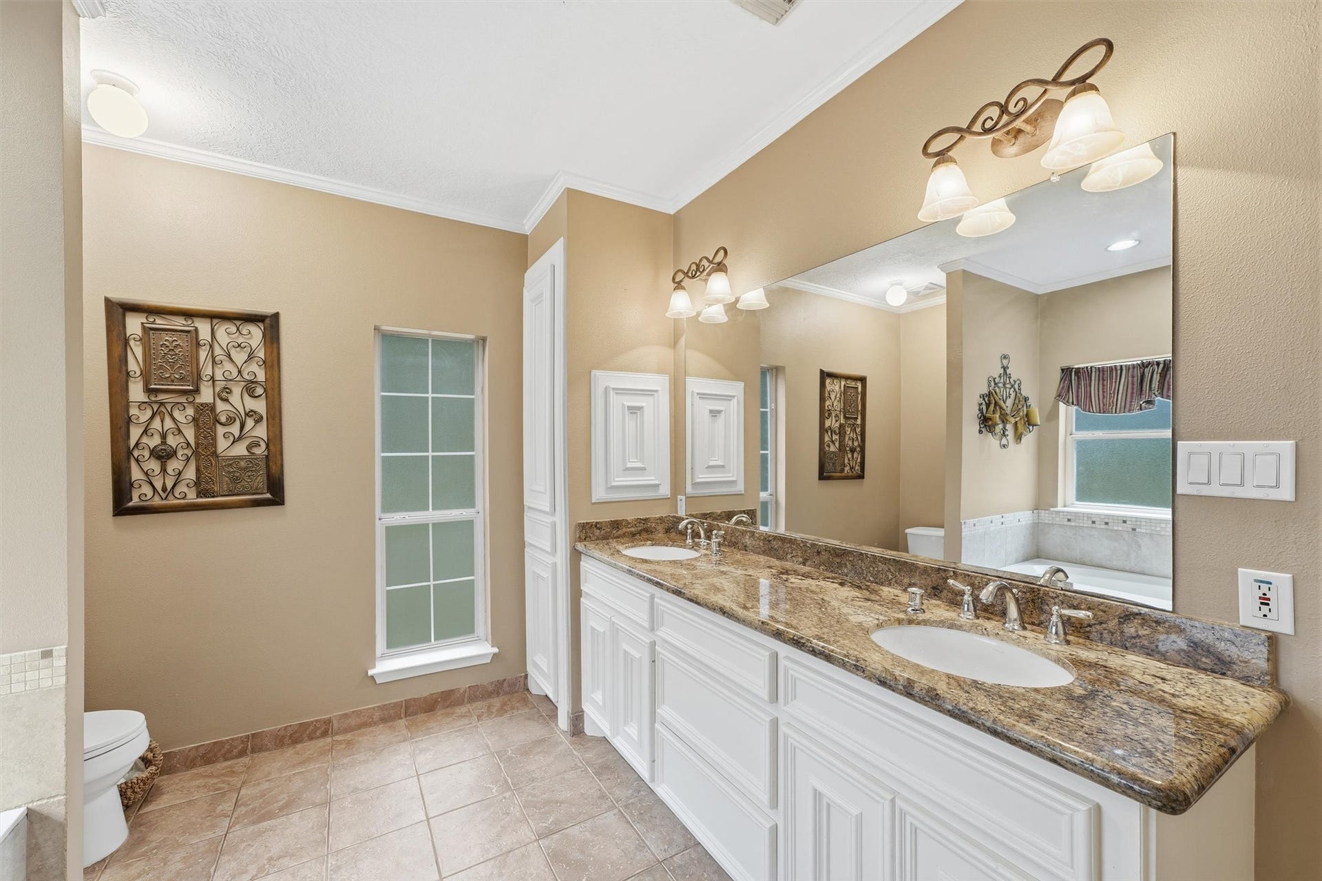 Primary bath featuring dual sinks and expansive countertop, providing plenty of room for everyday essentials.