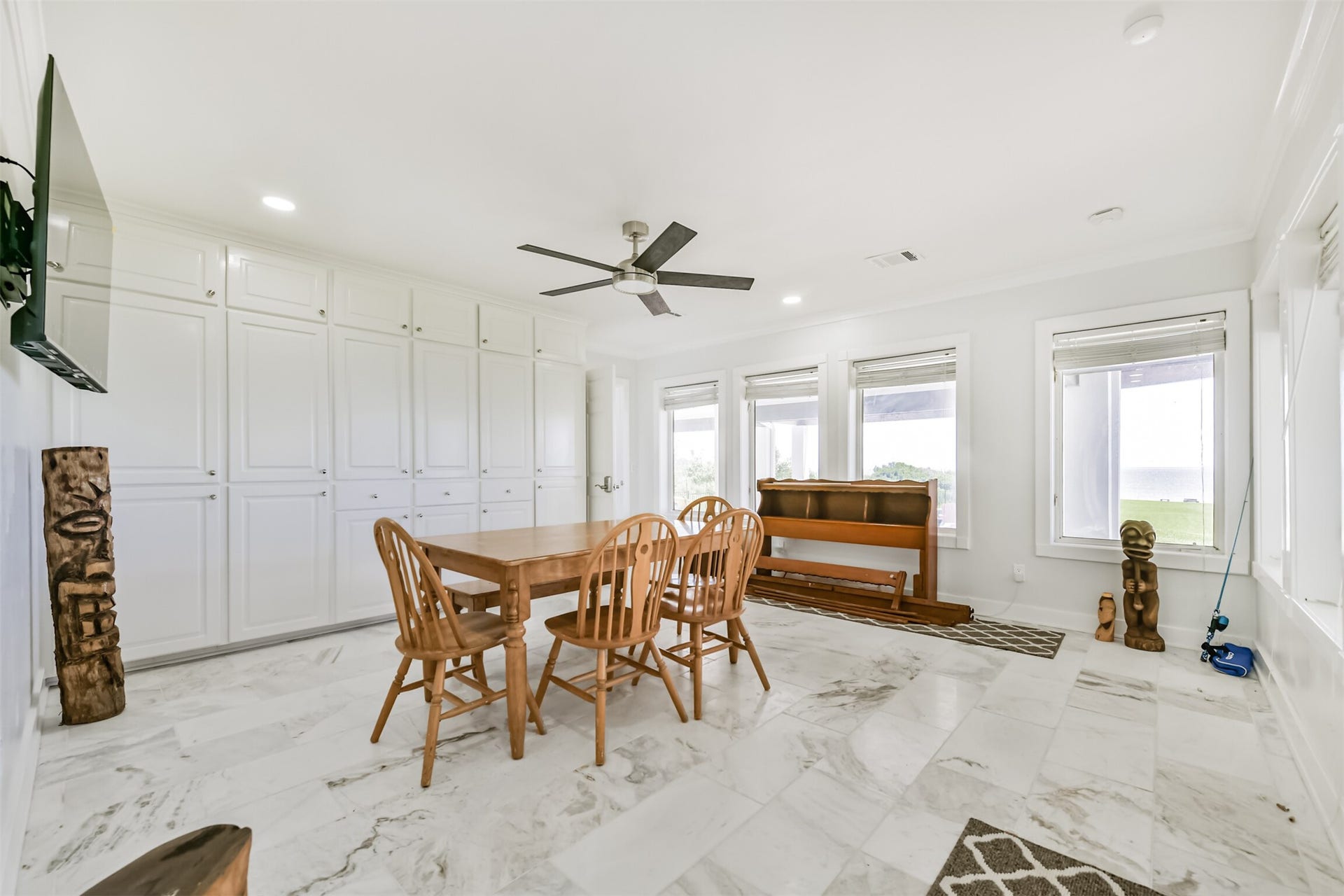 Bright and airy room featuring elegant marble flooring, ample built-in storage, and large windows offering serene views.