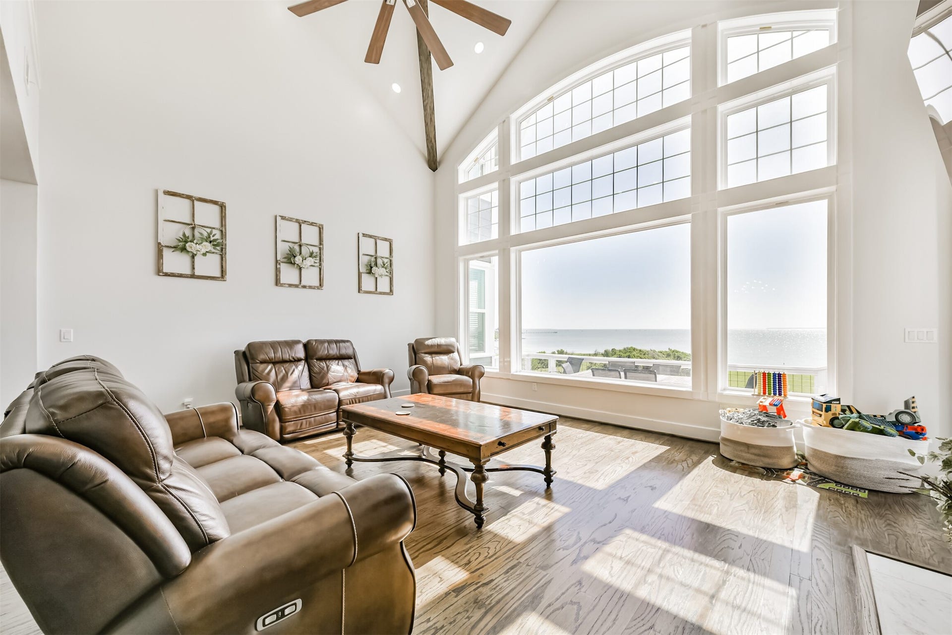 Breathtaking views from this elegant living room featuring soaring ceilings, expansive windows, and luxurious leather seating.