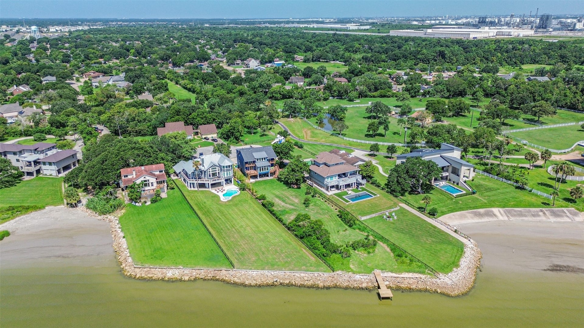 Waterfront home with expansive lawns and private pools, offering breathtaking views and direct access to the serene shoreline.
