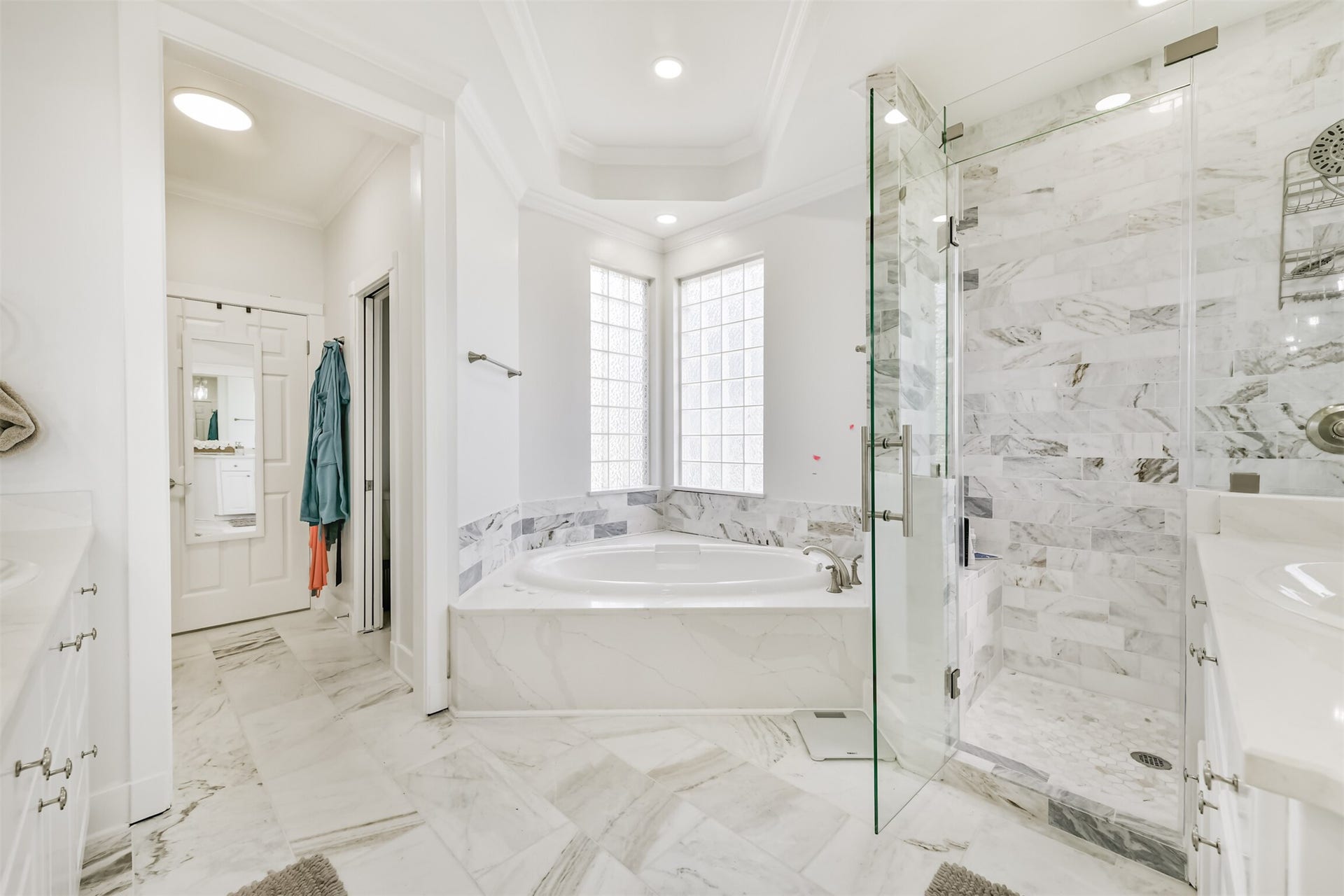 Luxurious bathroom featuring a spacious soaking tub, elegant marble tiles, and a frameless glass shower for a spa-like retreat.