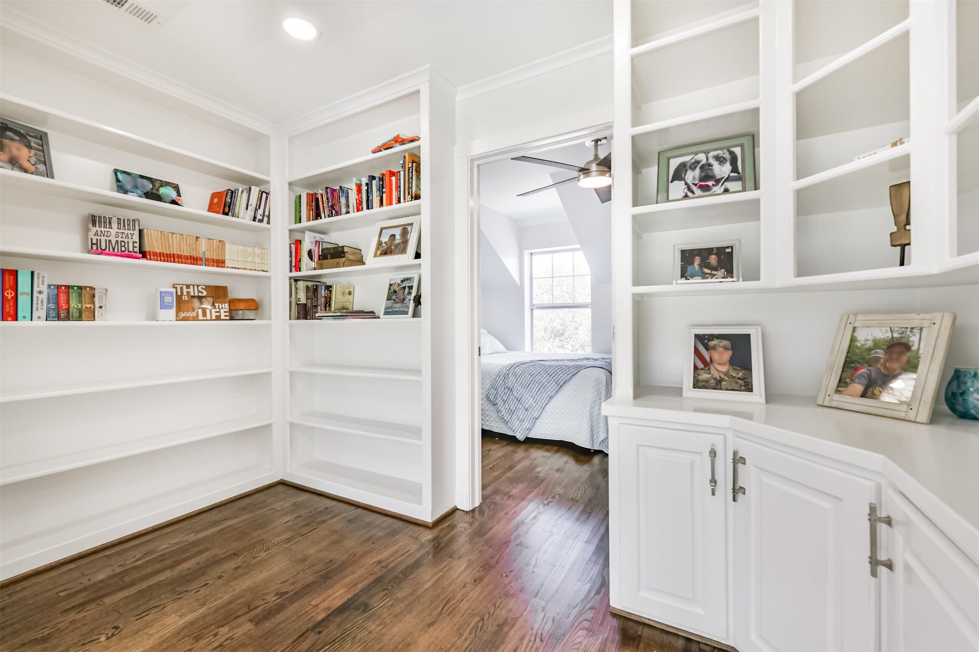 Inviting home library with built-in shelves leads to a cozy bedroom filled with natural light.
