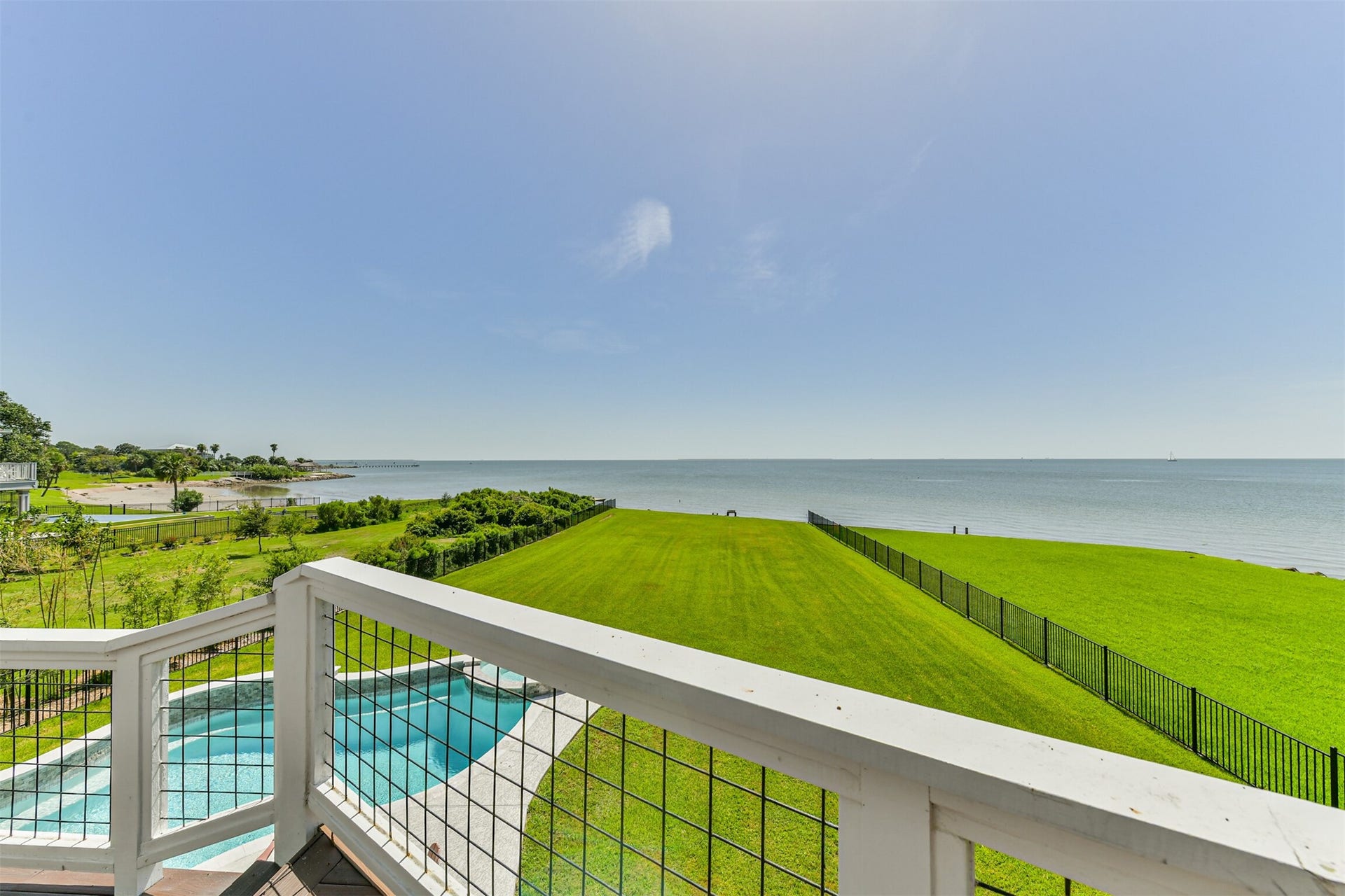 Stunning oceanfront view with expansive green lawns and a sparkling pool, perfect for relaxing and enjoying the coastal breeze.