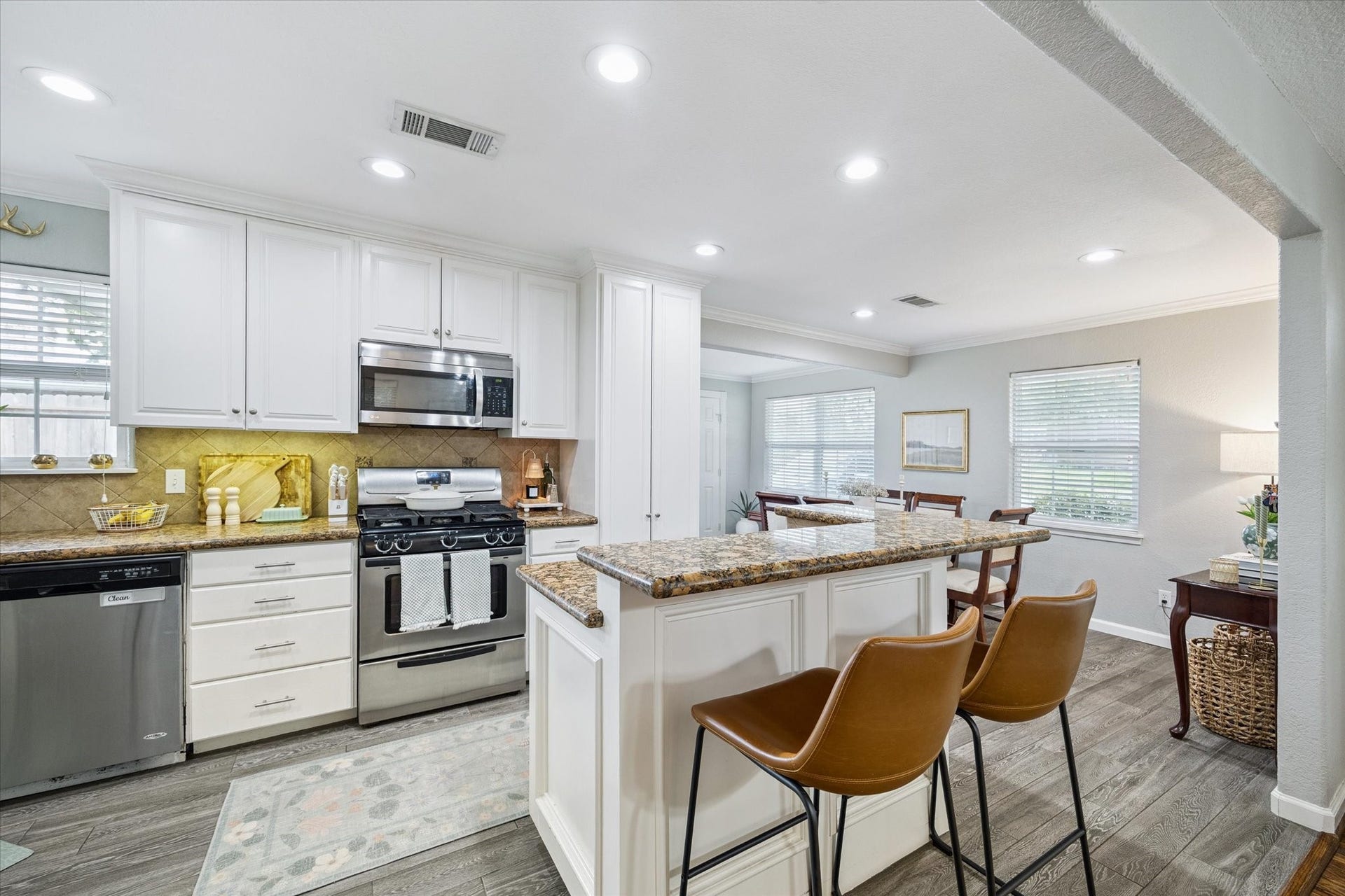 The kitchen features granite countertops, recessed lighting, and an oversized island with breakfast bar seating and additional storage.