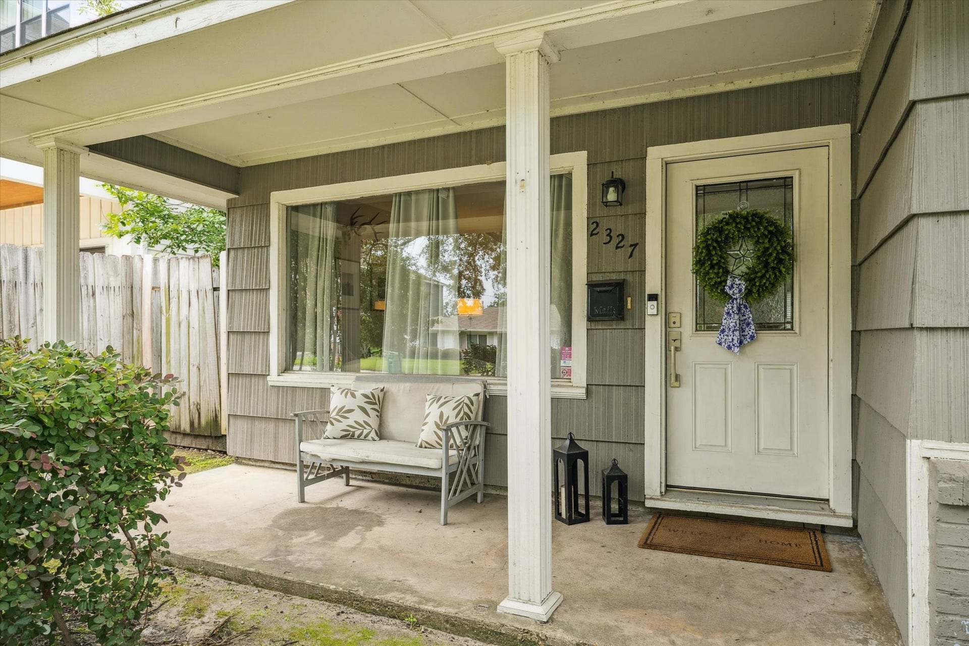 A cozy covered porch with room for seating adds functionality and charm to the home's inviting entrance.