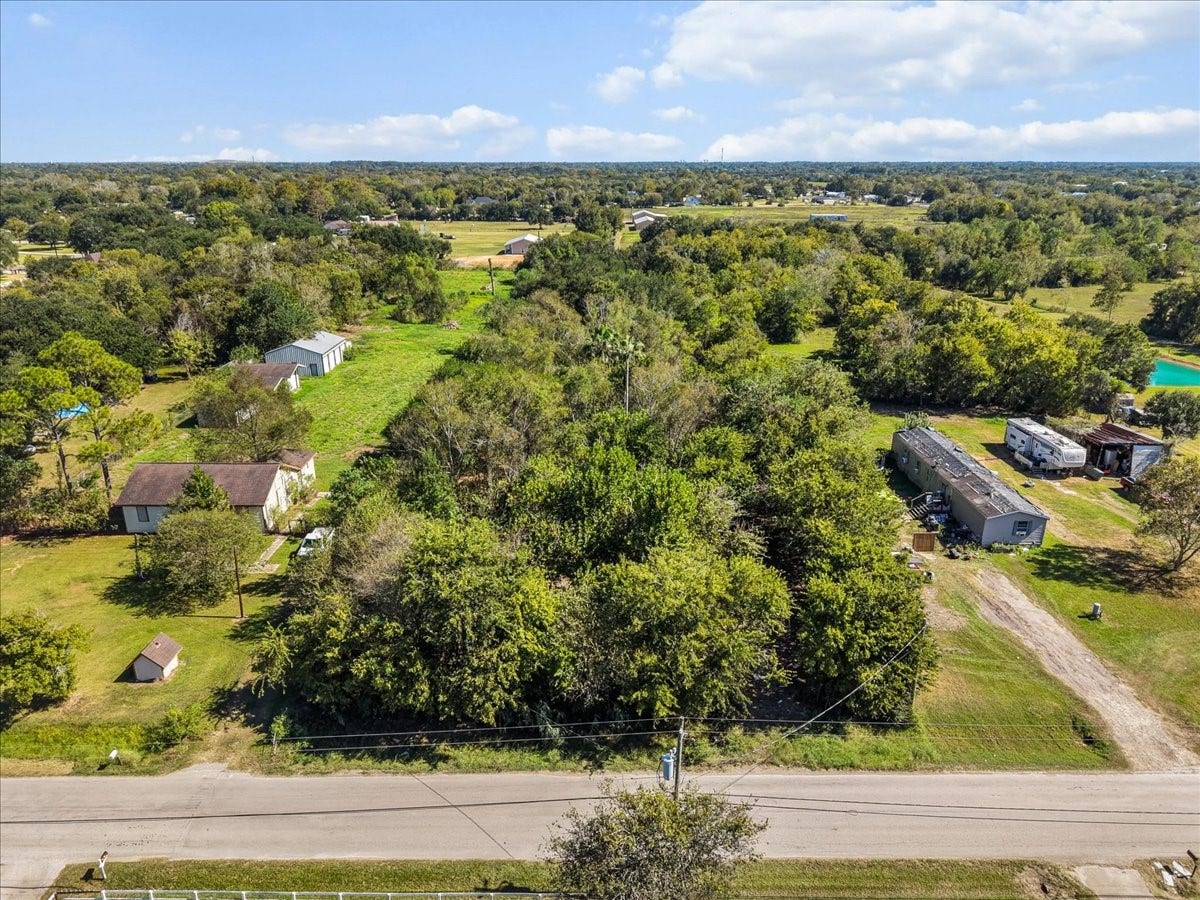 5029 1/2 Ike Franks Road, Santa Fe, TX 77517 A street view of the property showing its mature trees. The vegetation provides ample shade and could definitely enhance a future homesite.