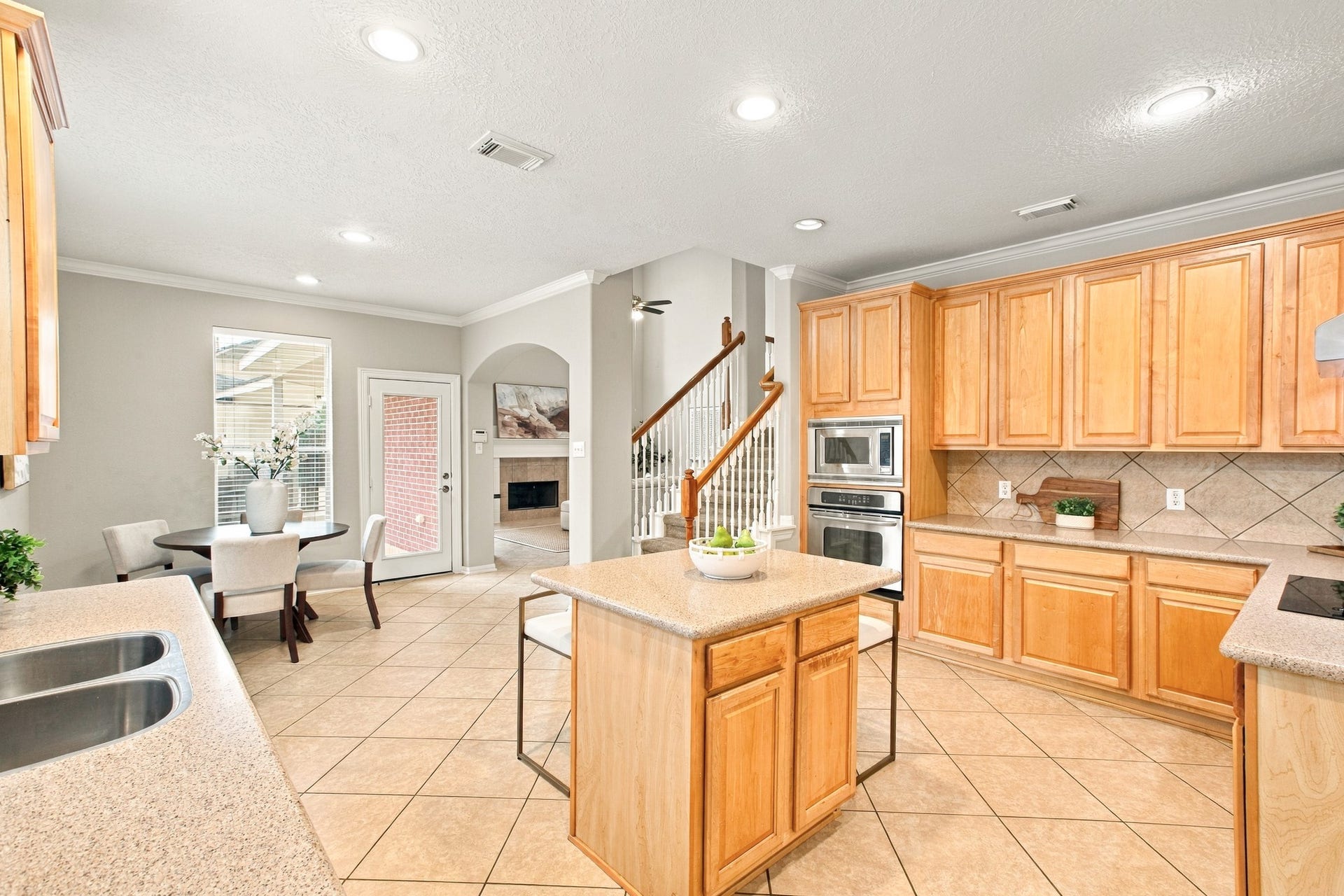 Spacious kitchen featuring cabinetry, generous counter space, a center island, and an open layout overlooking the breakfast area.