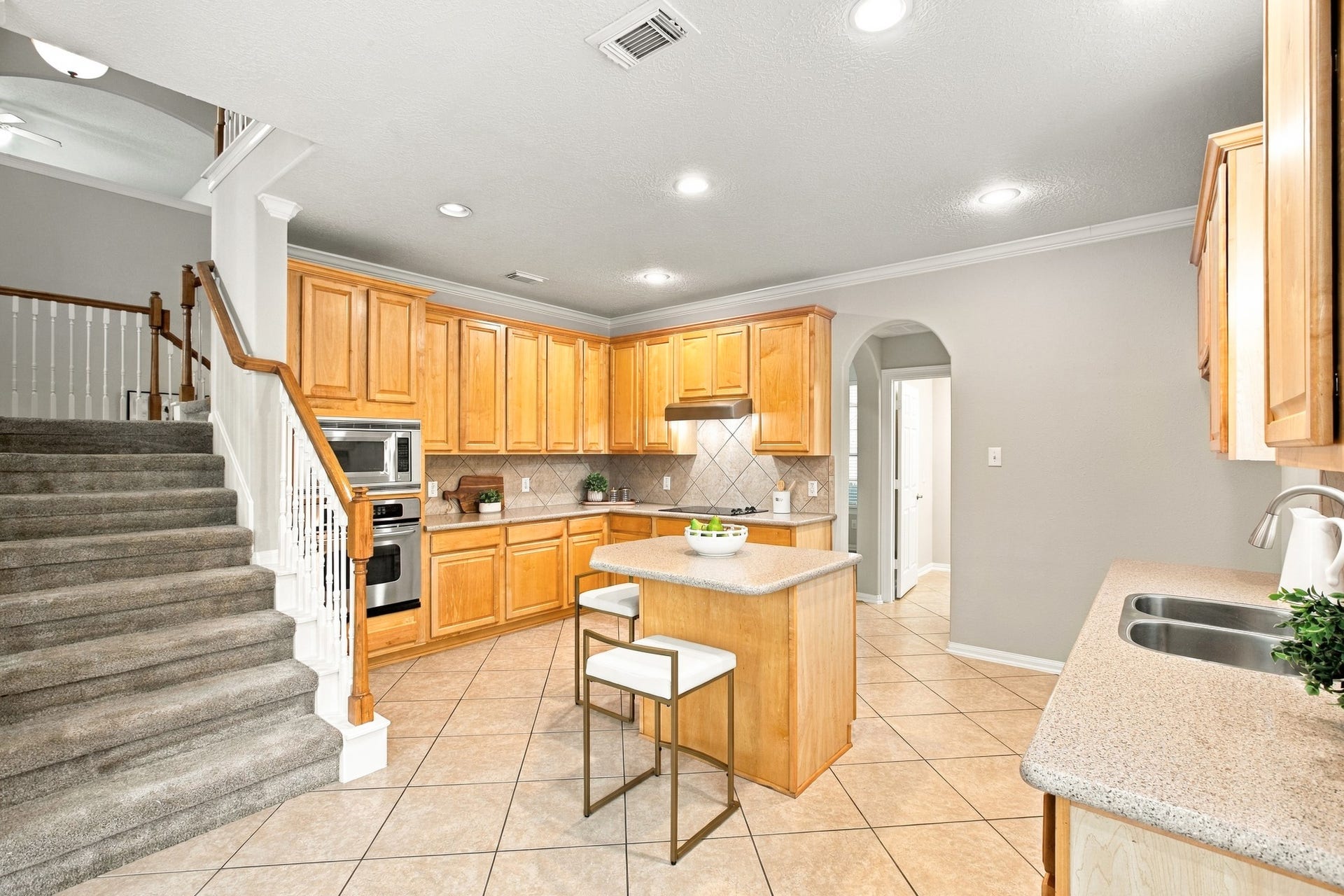 Well-appointed kitchen offering ample storage, expansive countertops, a center island with seating, and built-in appliances.