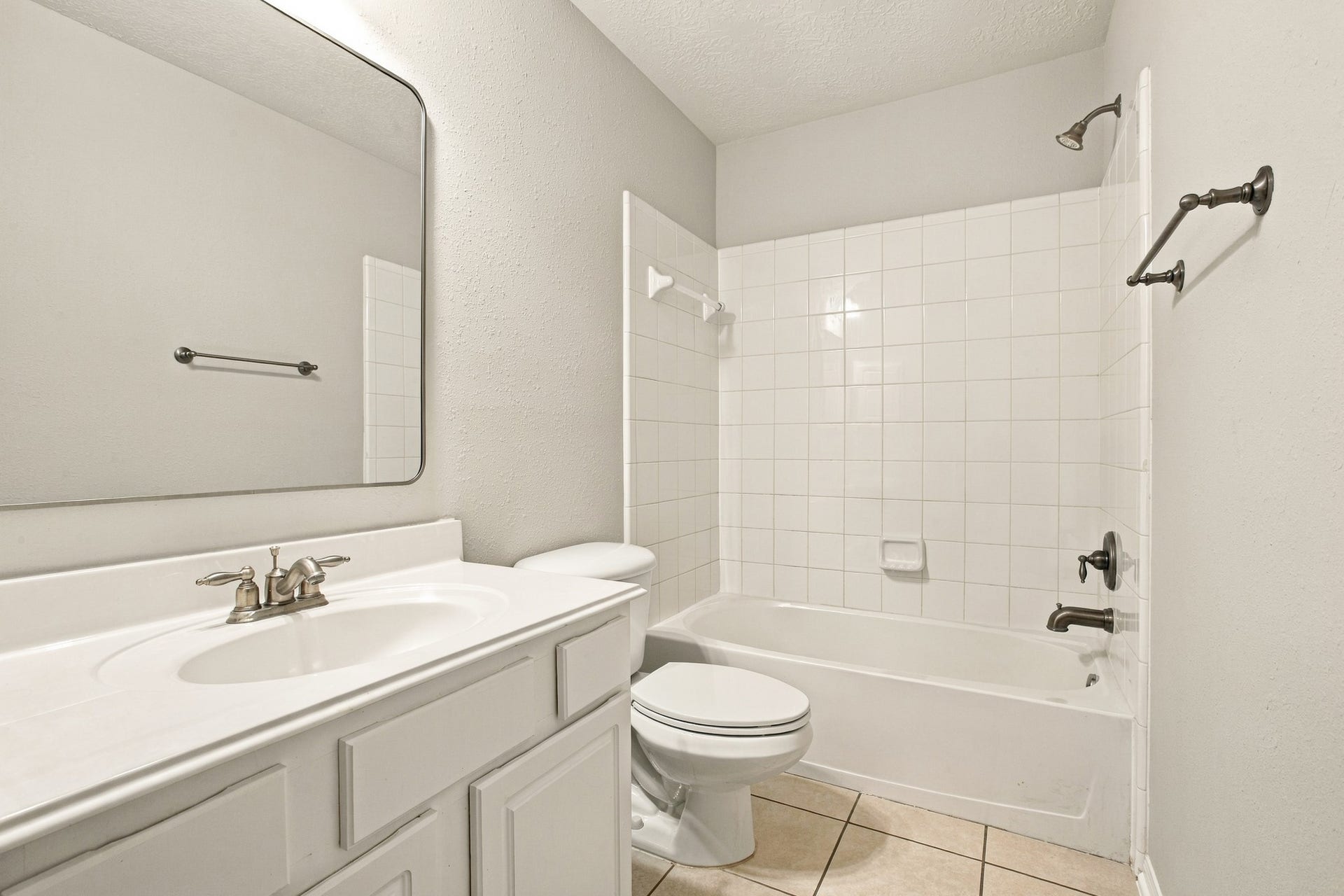 Secondary bathroom with spacious vanity with storage and a separate tub and shower area for added convenience.