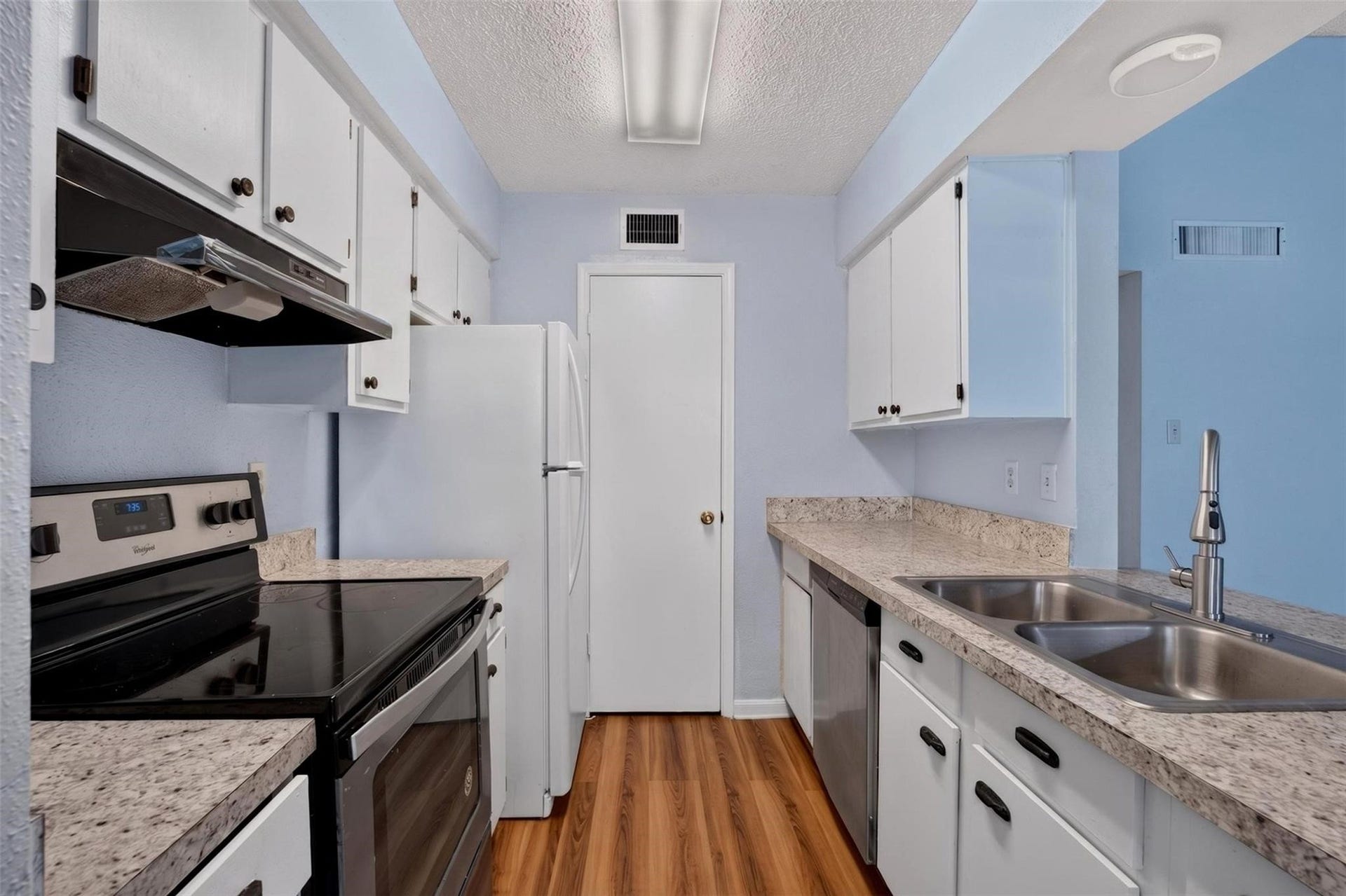 700 Thicket Lane, #304, Houston, TX 77079 Charming kitchen with sleek granite countertops, modern stainless steel appliances, and ample cabinet space, complemented by warm wood flooring and soft pastel walls.