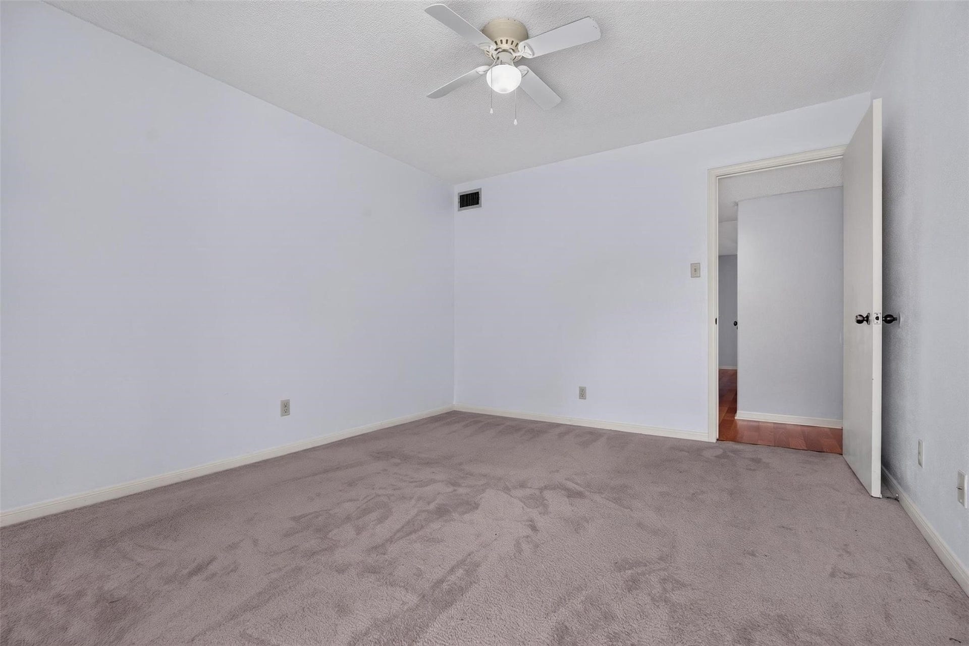 700 Thicket Lane, #304, Houston, TX 77079 Spacious bedroom with plush carpeting, neutral walls, and a ceiling fan, offering a cozy and inviting atmosphere.