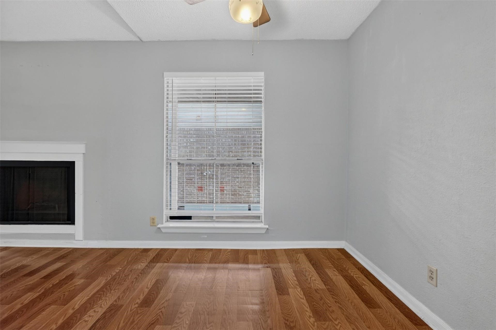 700 Thicket Lane, #304, Houston, TX 77079 Bright room featuring sleek hardwood floors, a cozy fireplace, and a large window offering ample natural light.