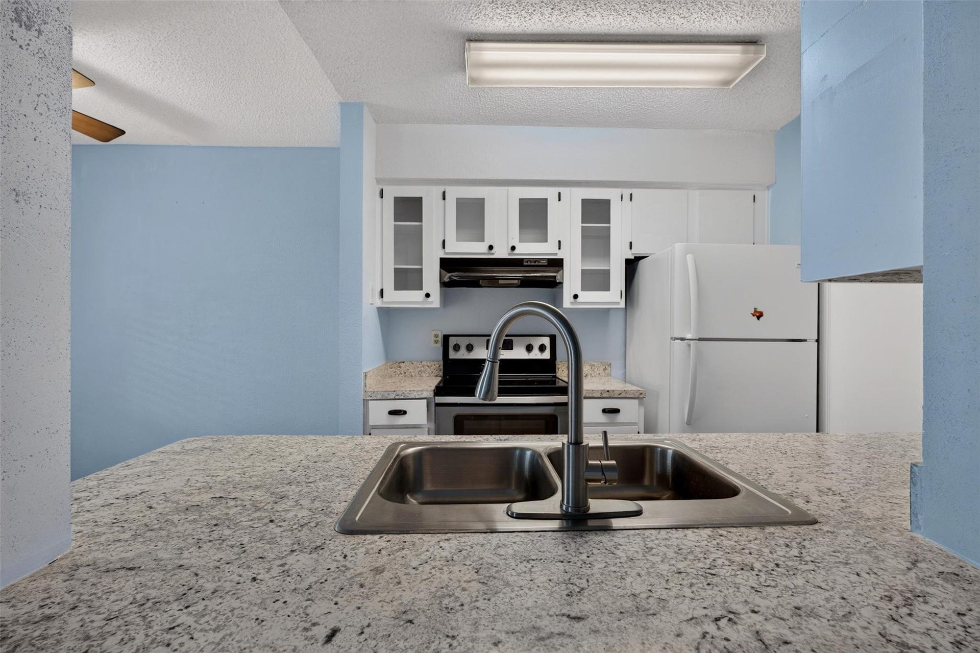 700 Thicket Lane, #304, Houston, TX 77079 Charming kitchen with granite countertops, white cabinetry, and modern appliances, offering a cozy and functional space for cooking and entertaining.