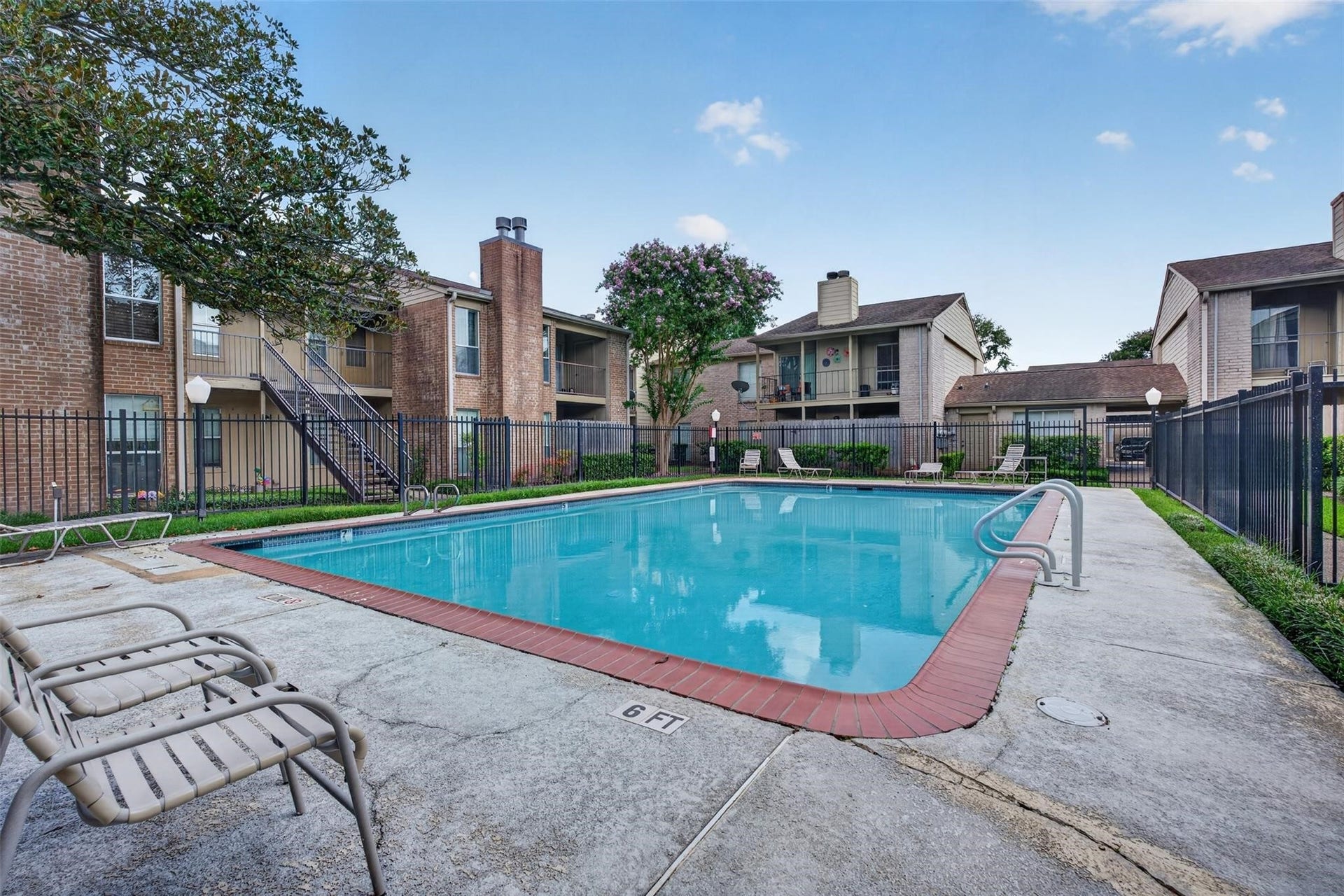 700 Thicket Lane, #304, Houston, TX 77079 Enjoy the serene ambiance of this inviting community pool, surrounded by well-maintained landscaping and charming brick apartment buildings.