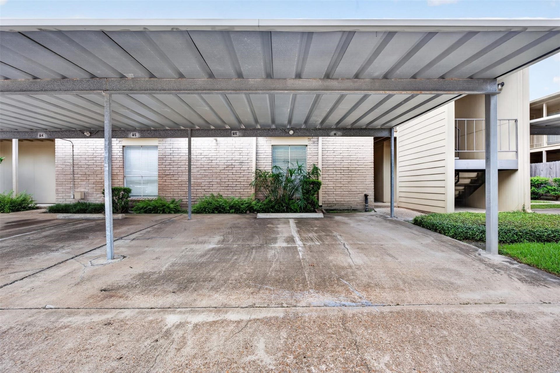 700 Thicket Lane, #304, Houston, TX 77079 Covered parking provides convenient protection from the elements, with easy access to the entrance and well-maintained landscaping.