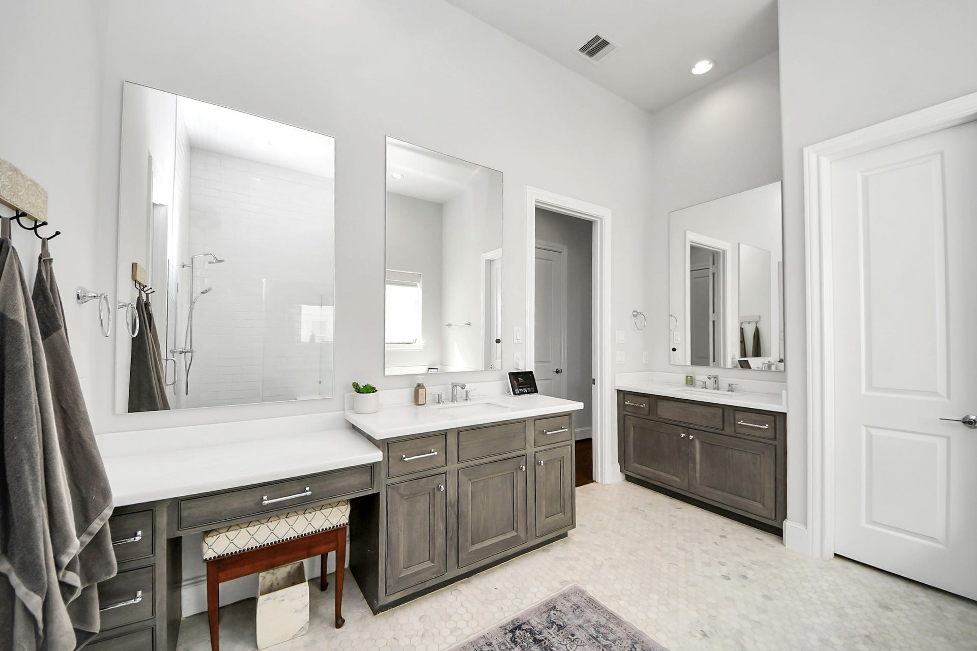 Spacious and elegant bathroom featuring dual vanities, modern fixtures, and ample natural light, perfect for a serene retreat.