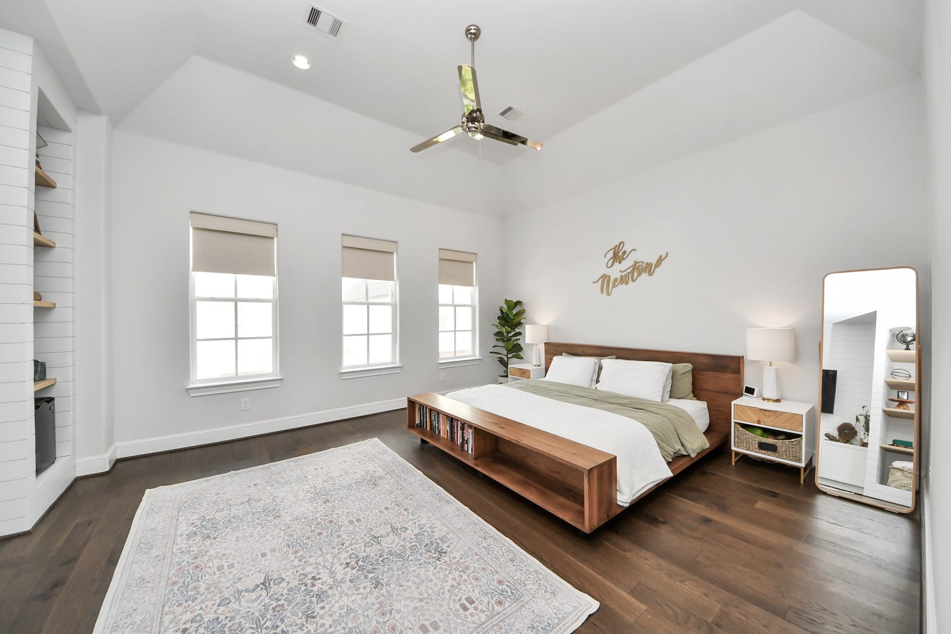 Spacious and bright primary bedroom featuring high ceilings, elegant hardwood floors, and large windows for natural light.