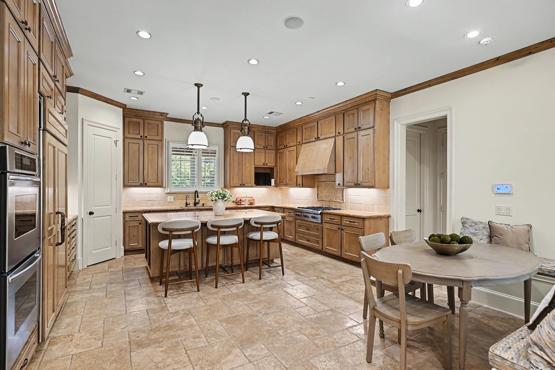 The kitchen and breakfast room offer open yet defined spaces, with double wall ovens adding convenience for everyday cooking and entertaining.