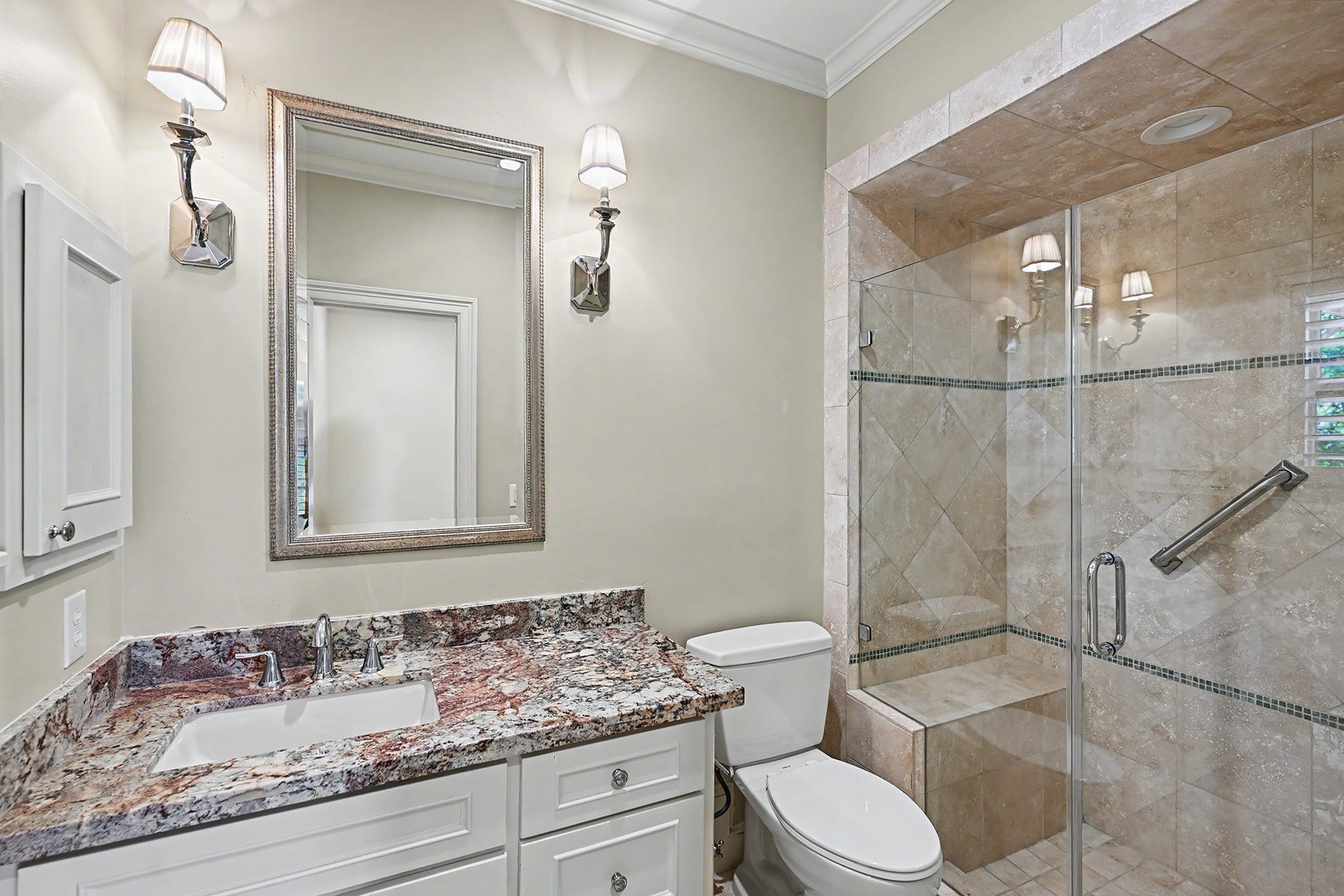 The ensuite bathroom includes a glass-enclosed walk-in shower with a built-in bench.