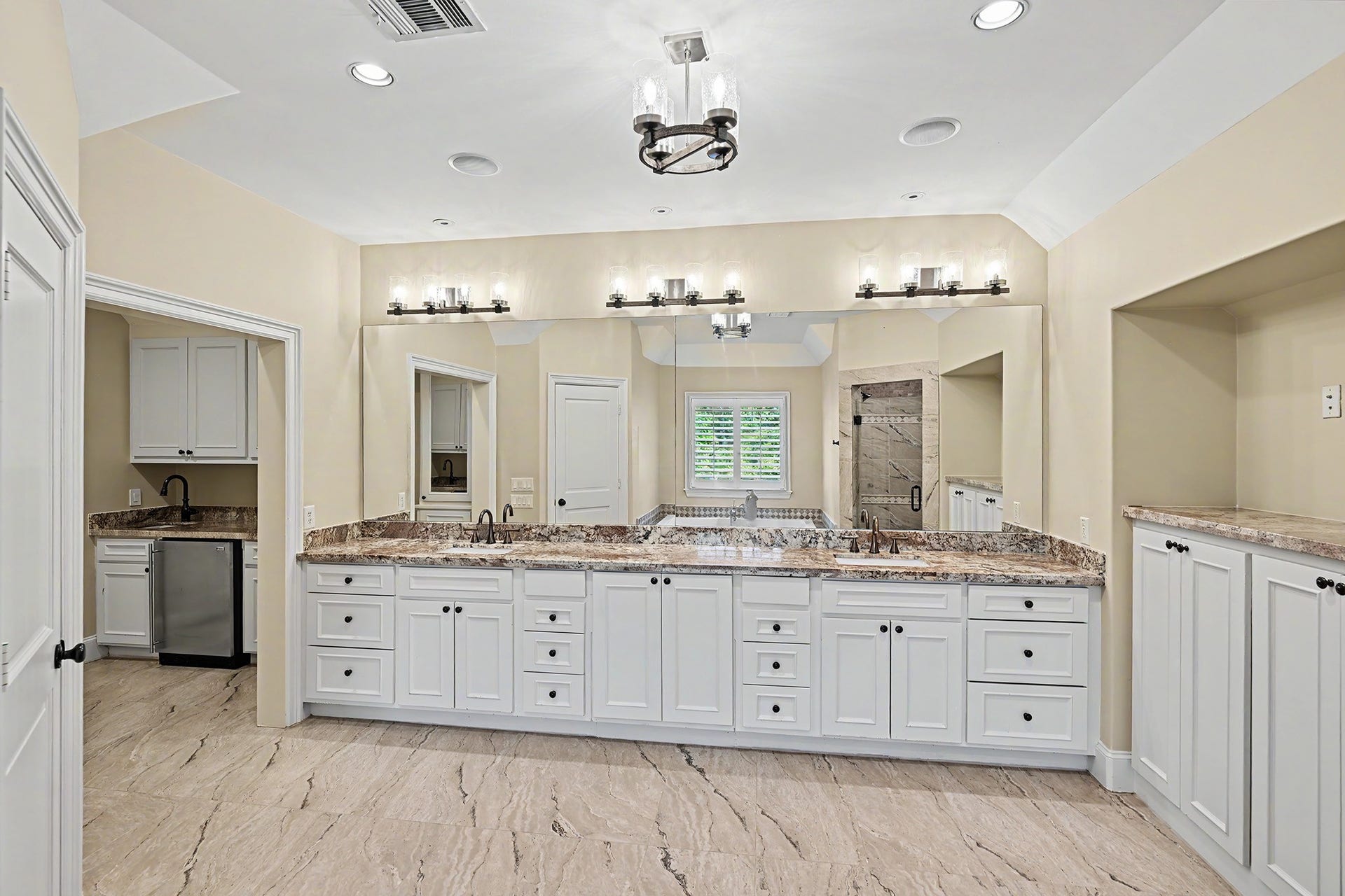 Another view of the primary bath showcasing the built-in cabinetry and storage, with convenient access to the adjoining flex room.