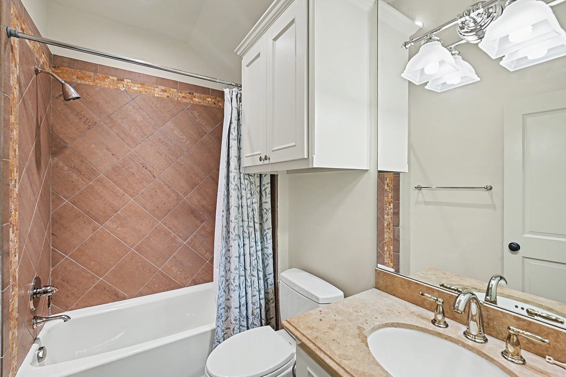 Ensuite bath to the third floor flex room with a tub/shower combo.