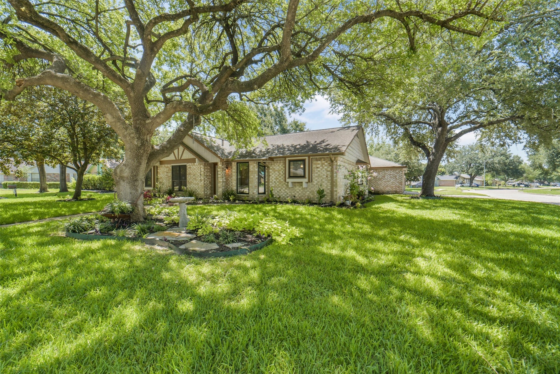 Expansive front yard shaded by mature trees, offering plenty of green space for landscaping.