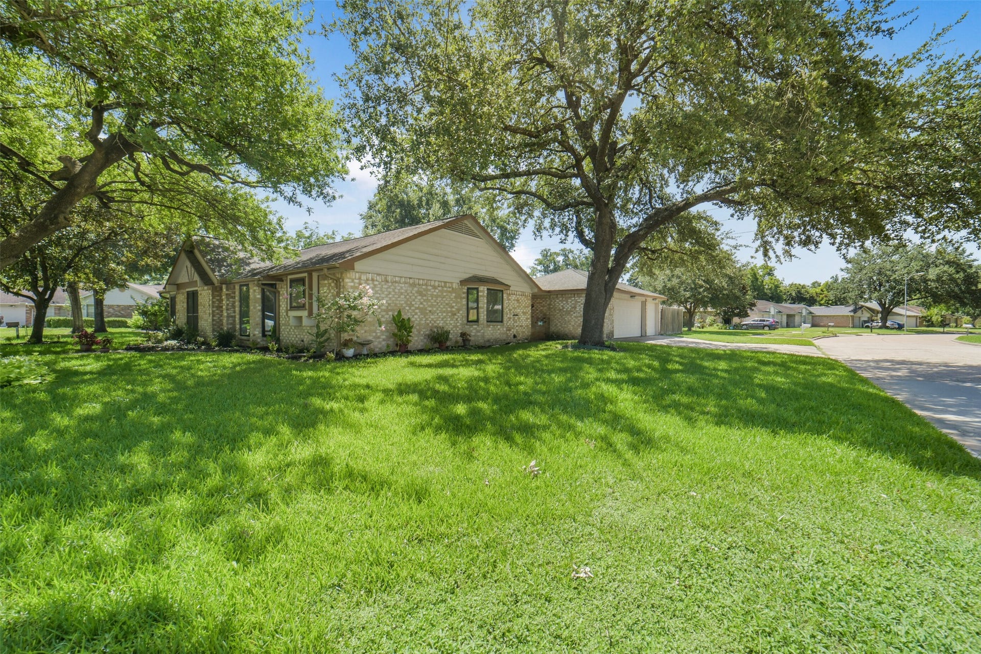 This home is located on corner lot, as you can see from the side street view the home is well-maintained and framed by towering shade trees and a spacious green lawn highlighting the property's peaceful curb appeal and inviting neighborhood setting.