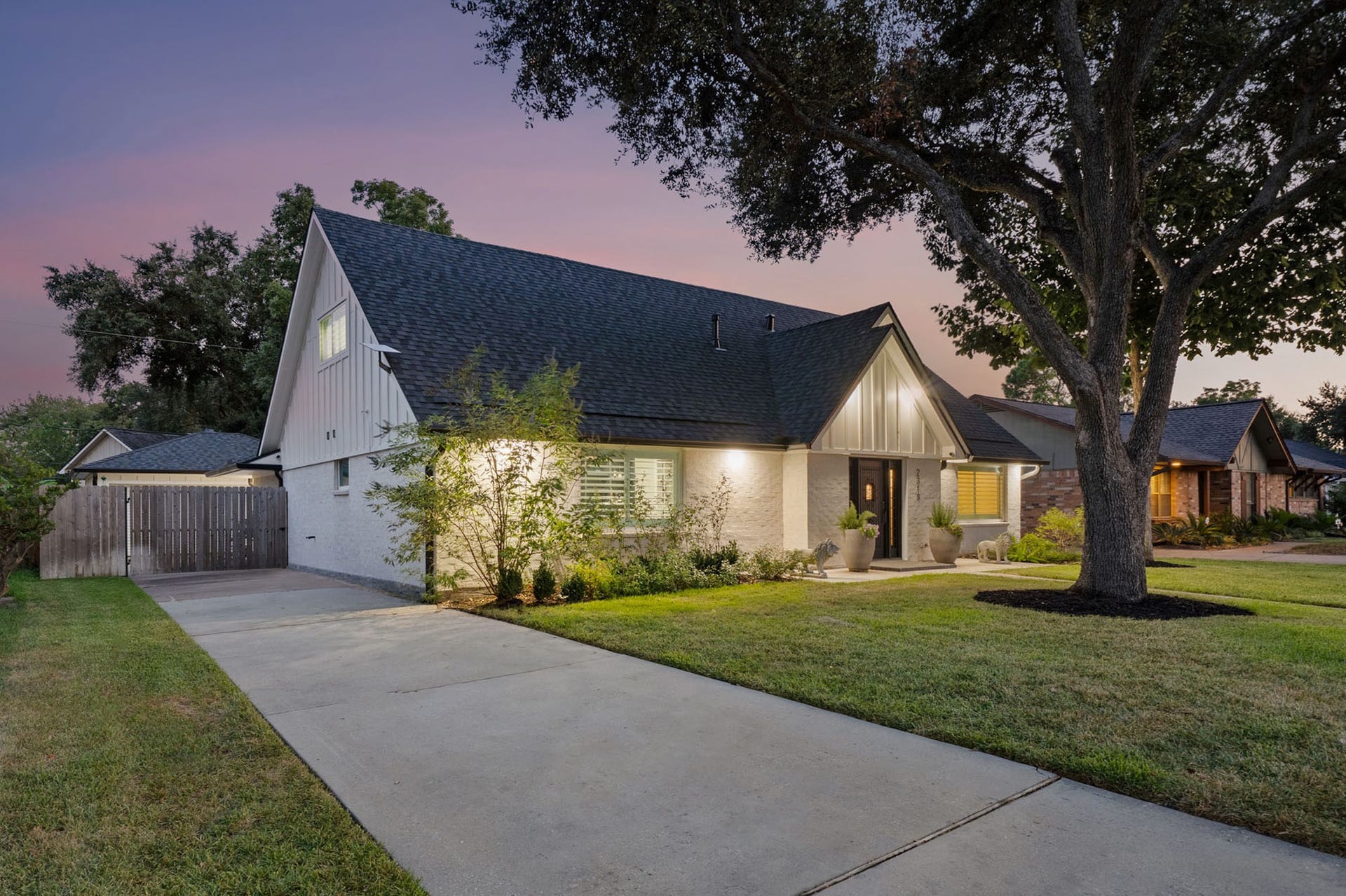 Welcoming front elevation highlighted by a dramatic 70-inch-wide entry with a centered iron door and glass sidelights.