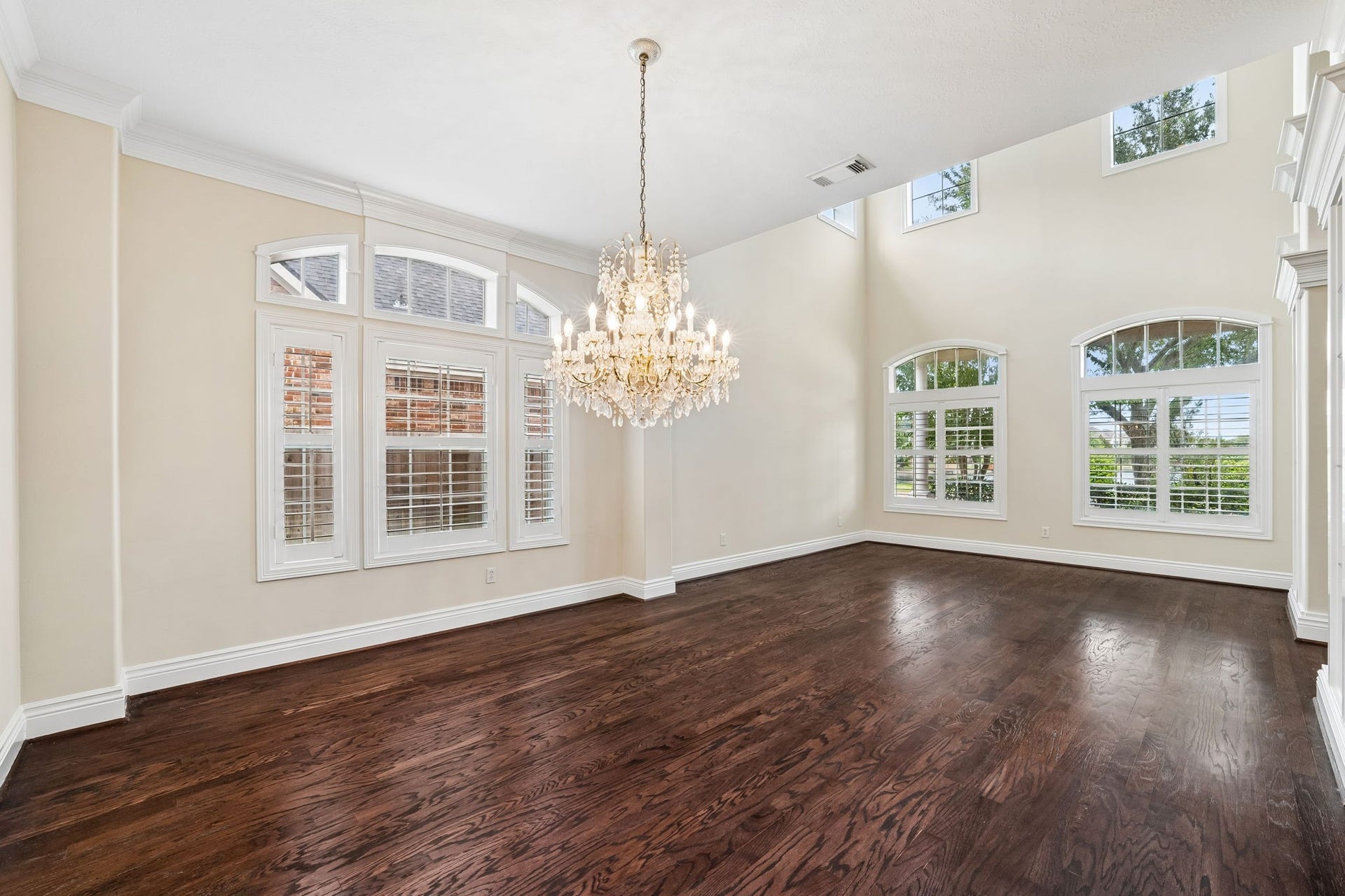 Elegant formal dining and formal living room featuring rich hardwood floors and abundant natural light.
