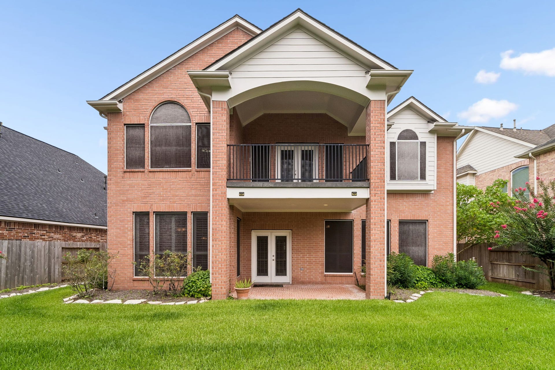 Rearview featuring lush greenery and balcony.