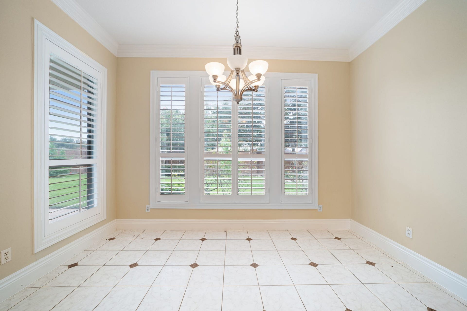 Spacious Breakfast area featuring tile flooring and windows with shutter blinds.