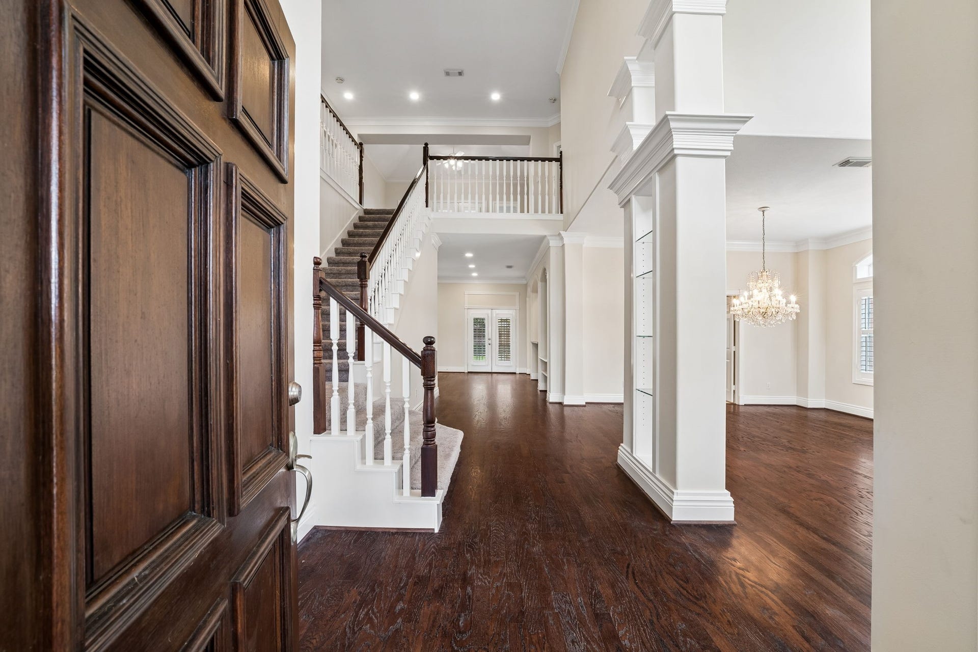 Stately brick entryway with elegant arched windows and a solid wood door, offering a warm welcome to this charming home.