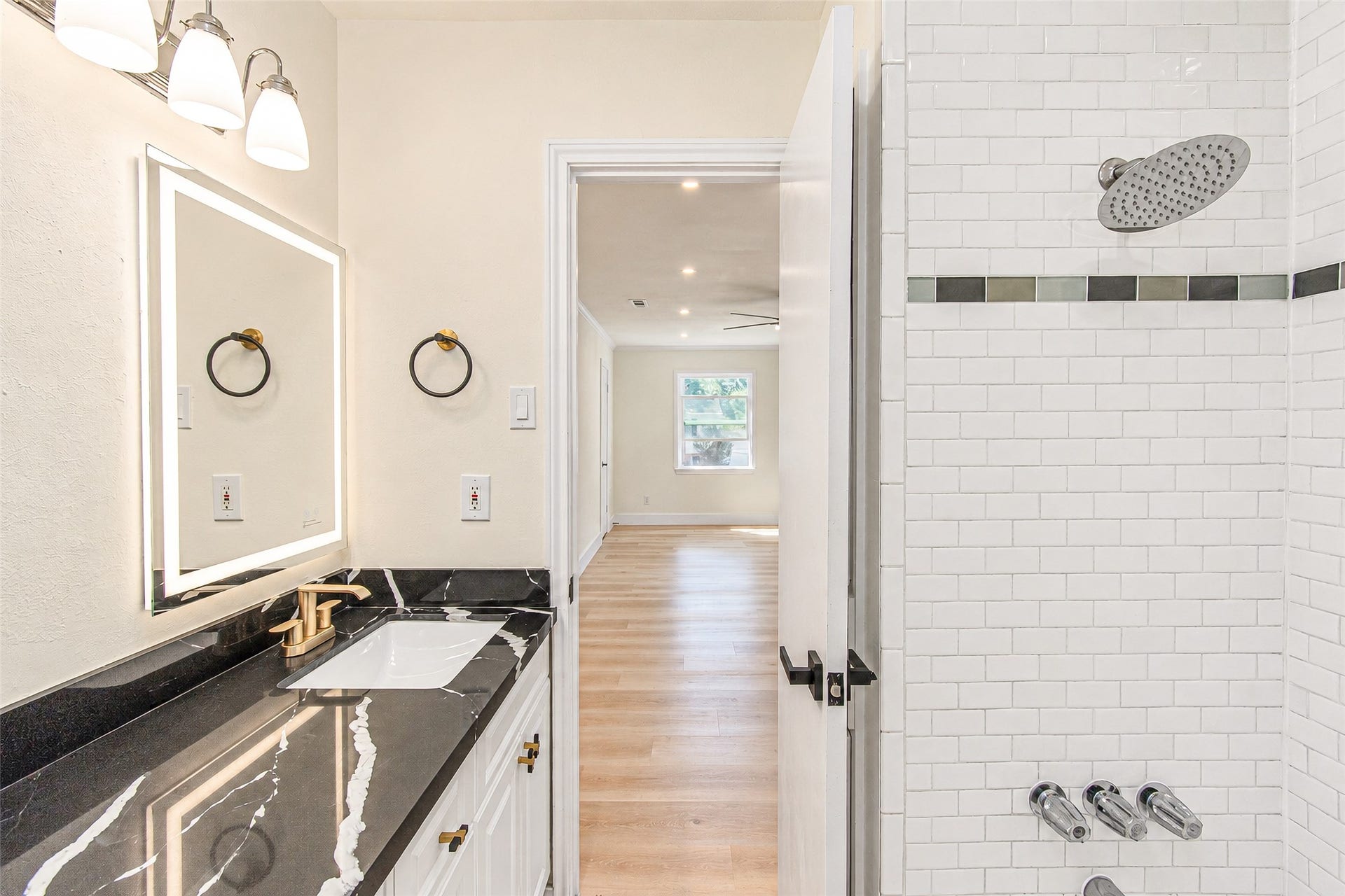 10610 Overbrook Lane, Houston, TX 77042 Elegant primary bath featuring a luxurious black quartz countertop, modern fixtures, and a stylish tiled shower for a spa-like retreat.