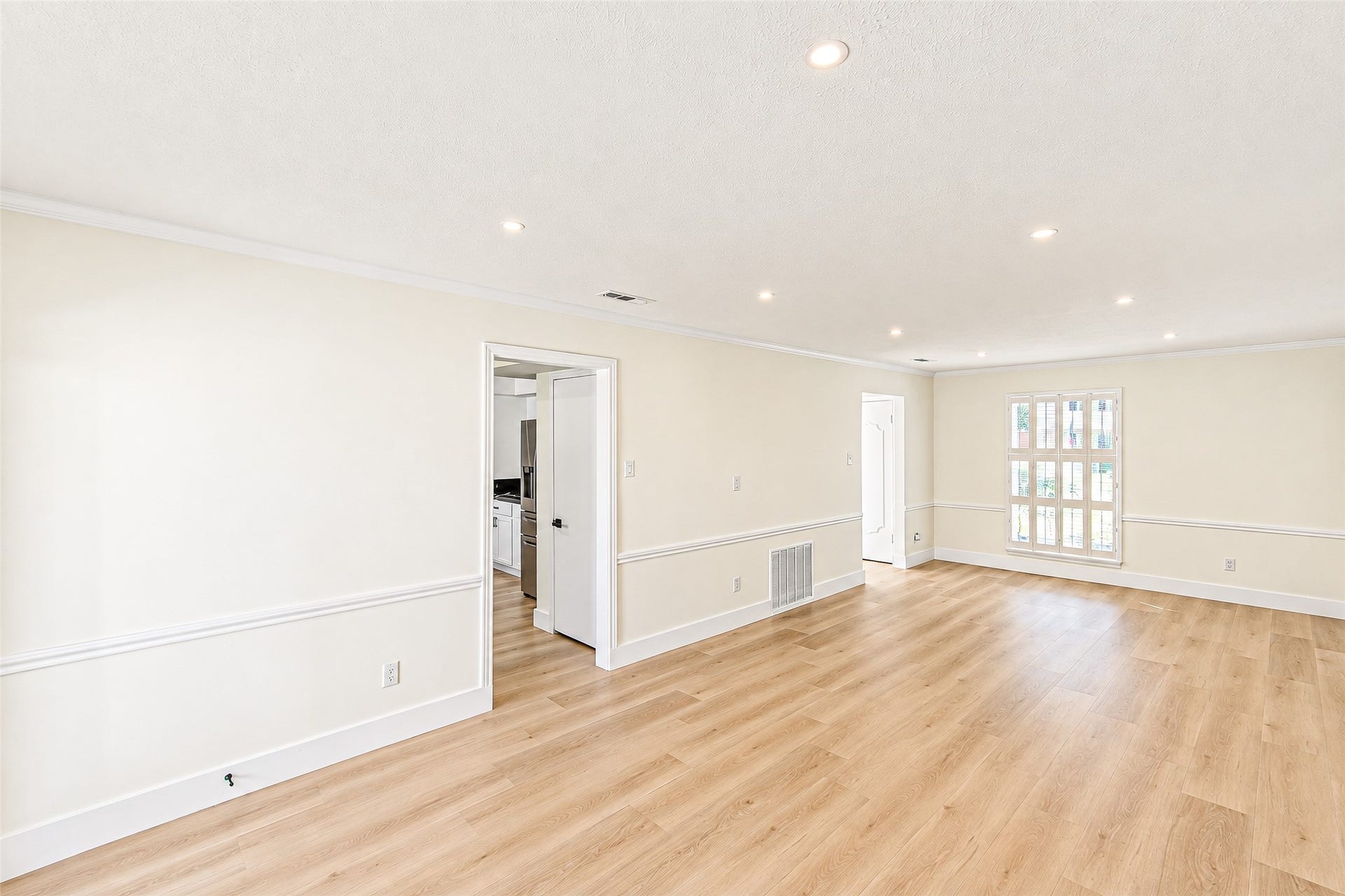 10610 Overbrook Lane, Houston, TX 77042 Bright and inviting, this expansive living area features elegant vinyl flooring, recessed lighting, and ample natural light, creating a perfect space for relaxation and entertaining.
