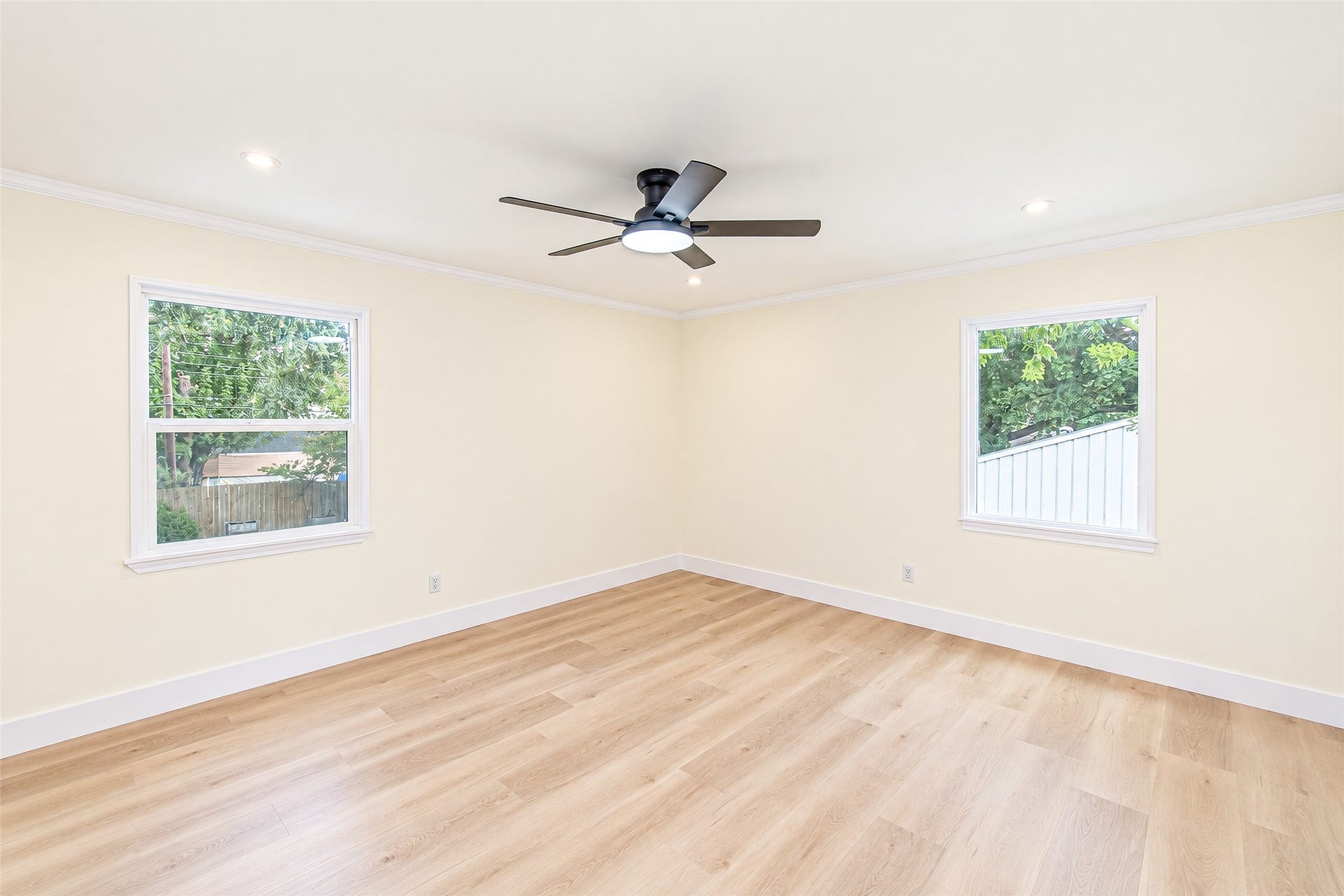 10610 Overbrook Lane, Houston, TX 77042 Experience tranquility in this spacious primary bedroom, featuring abundant natural light, elegant vinyl flooring, and a modern ceiling fan for ultimate comfort.