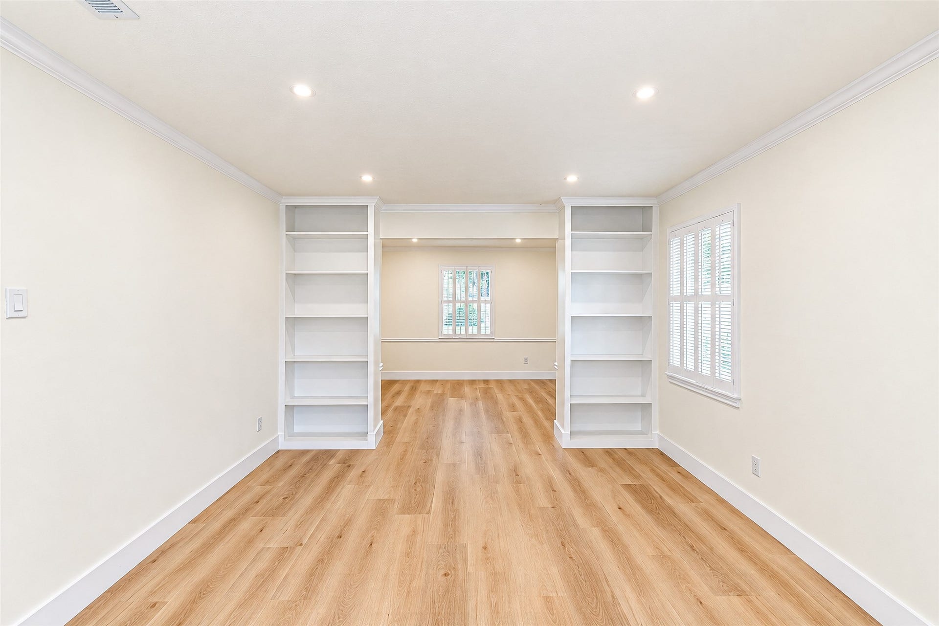10610 Overbrook Lane, Houston, TX 77042 Bright and inviting study featuring elegant built-in bookshelves, warm floors, and ample natural light for a perfect work-from-home retreat.