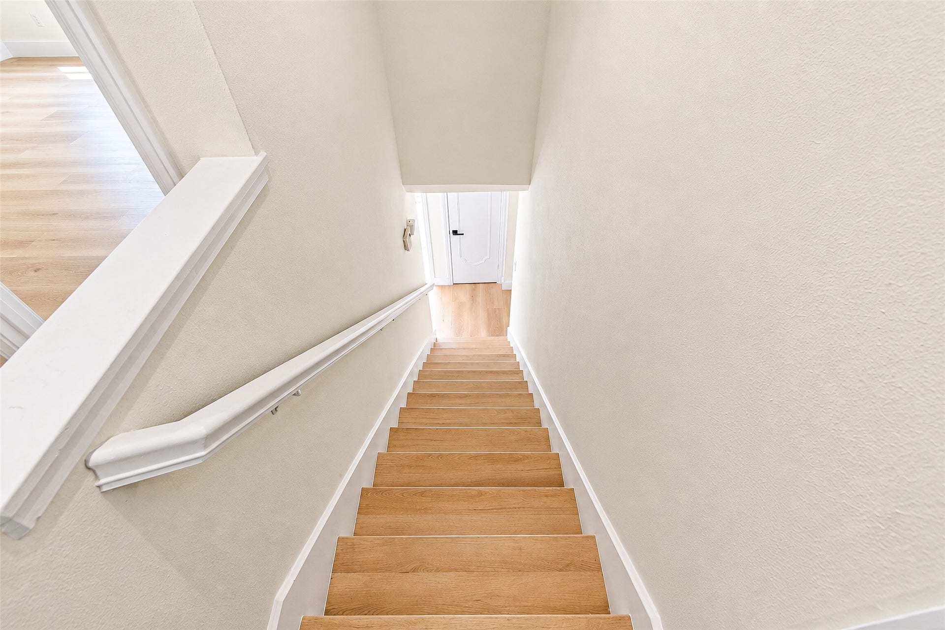 10610 Overbrook Lane, Houston, TX 77042 Bright, inviting staircase with sleek steps and crisp white walls leading to a lower level.