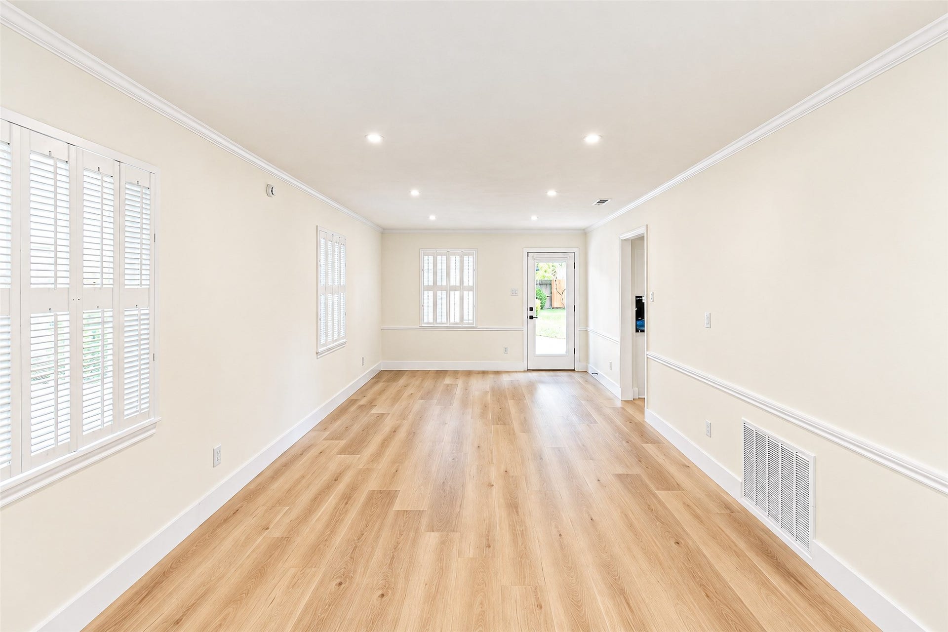 10610 Overbrook Lane, Houston, TX 77042 Bright and inviting, this spacious living room features elegant vinyl floors, abundant natural light, and seamless access to the outdoors through a stylish door.