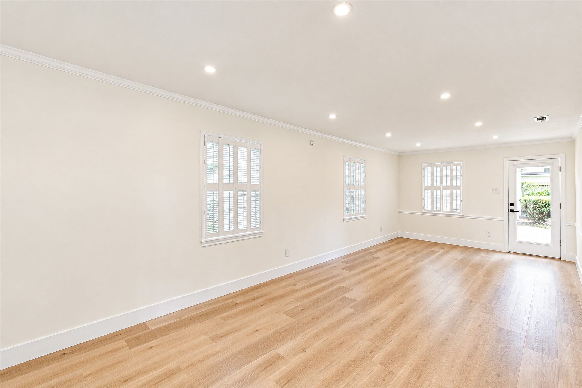 10610 Overbrook Lane, Houston, TX 77042 Bright and inviting, this spacious living room boasts elegant vinyl floors, abundant natural light, and seamless access to outdoor tranquility.