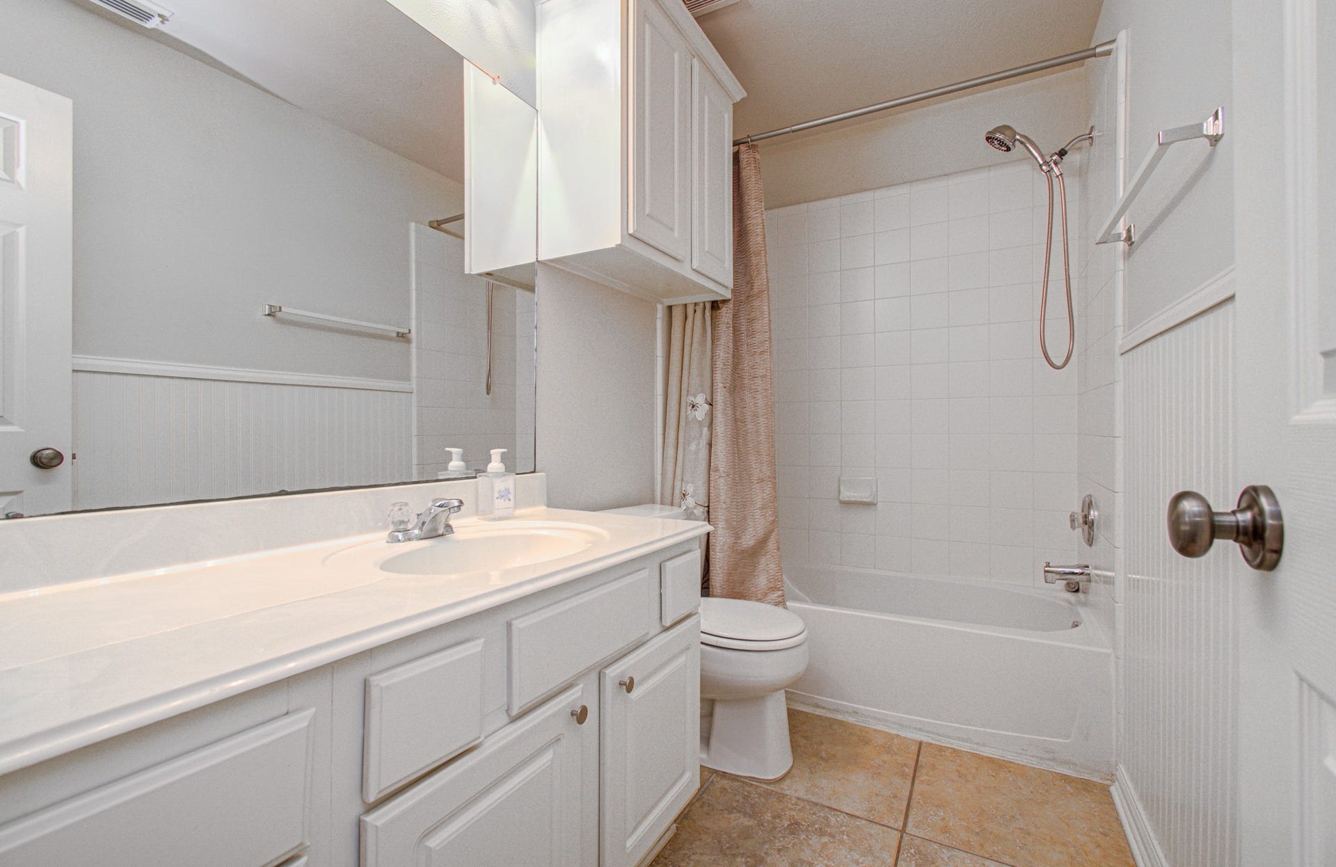 12808 Brook Arbor Court, Pearland, TX 77584 Bright and clean bathroom featuring a spacious vanity with ample storage, a tub-shower combination with elegant fixtures, and neutral tile flooring.