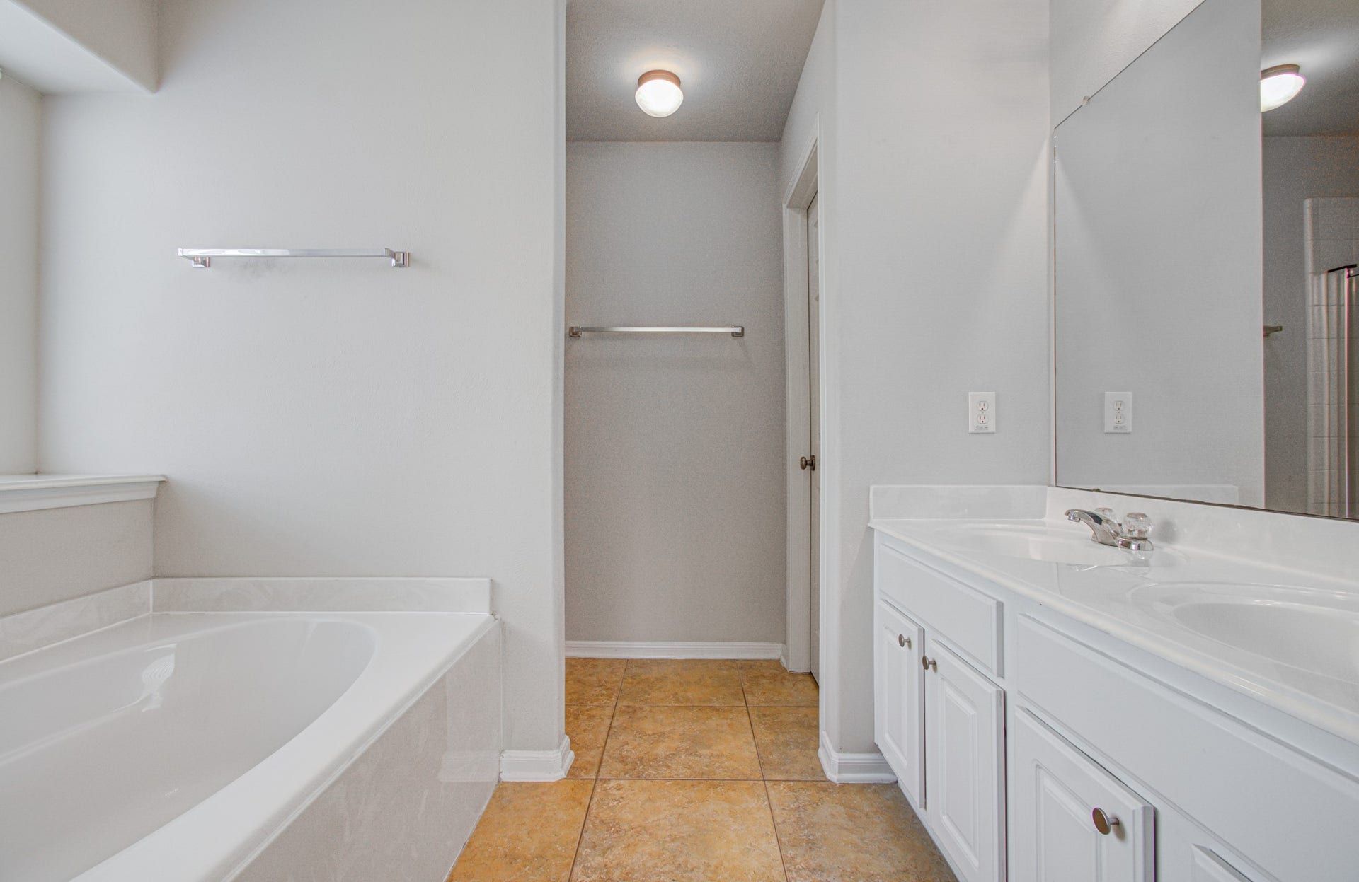 12808 Brook Arbor Court, Pearland, TX 77584 Primary bathroom features a luxurious soaking tub, dual-sink vanity, and elegant tile flooring for a serene retreat.