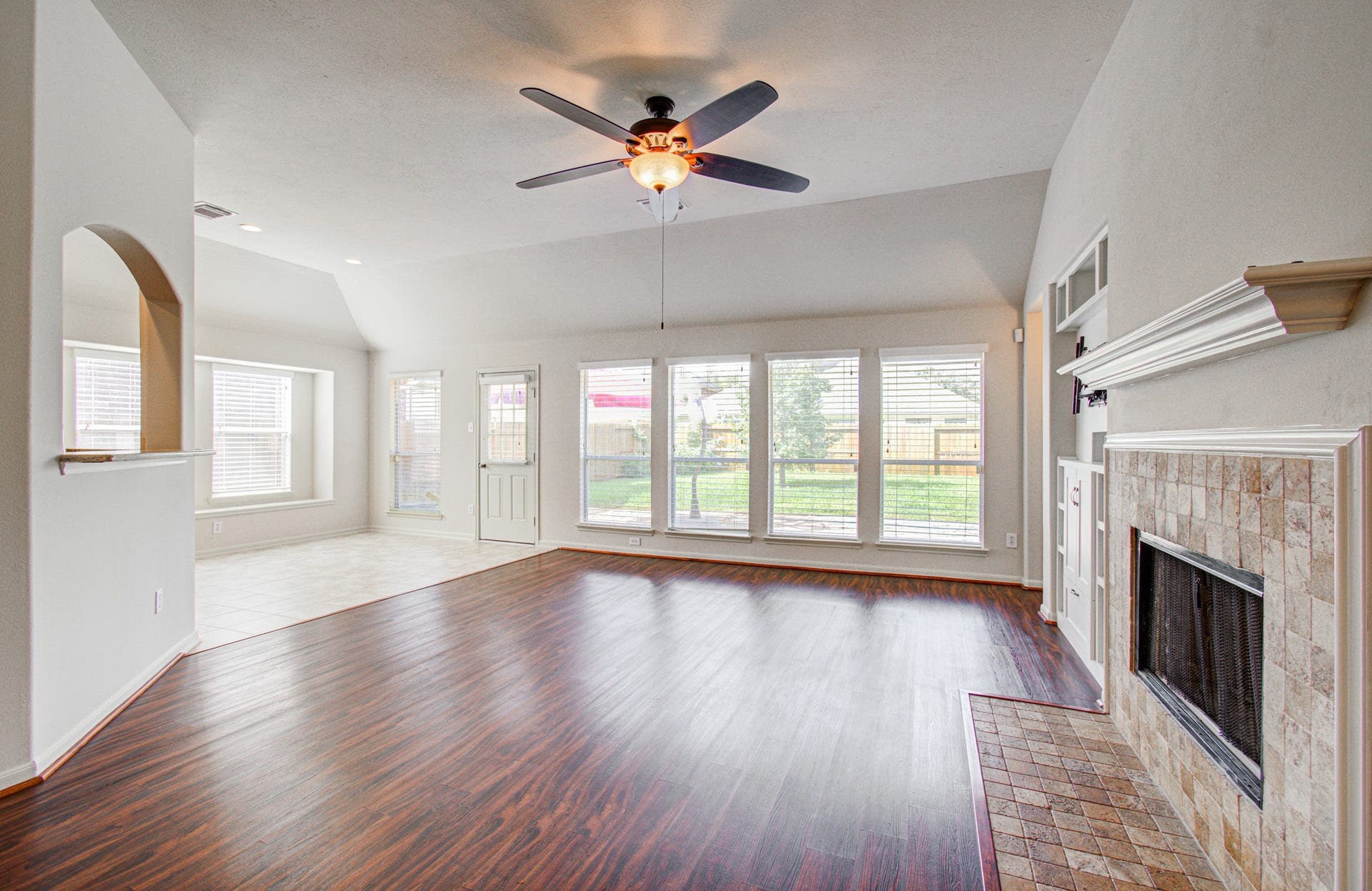 12808 Brook Arbor Court, Pearland, TX 77584 The spacious living area features a cozy fireplace and large windows offering abundant natural light and a view of the backyard.
