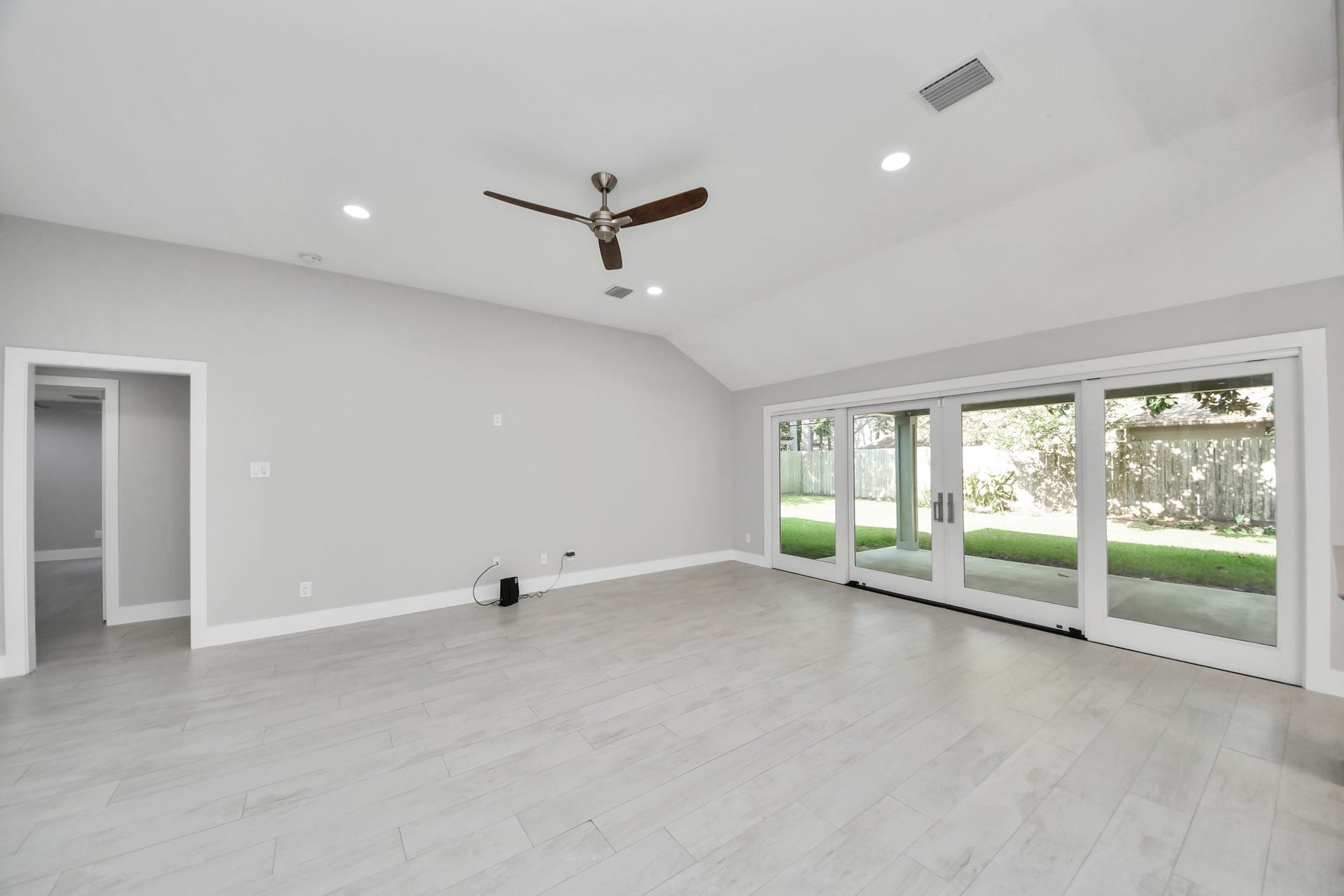 Spacious living room/great room showcasing a gorgeous sliding door and seamless ceramic tile flooring