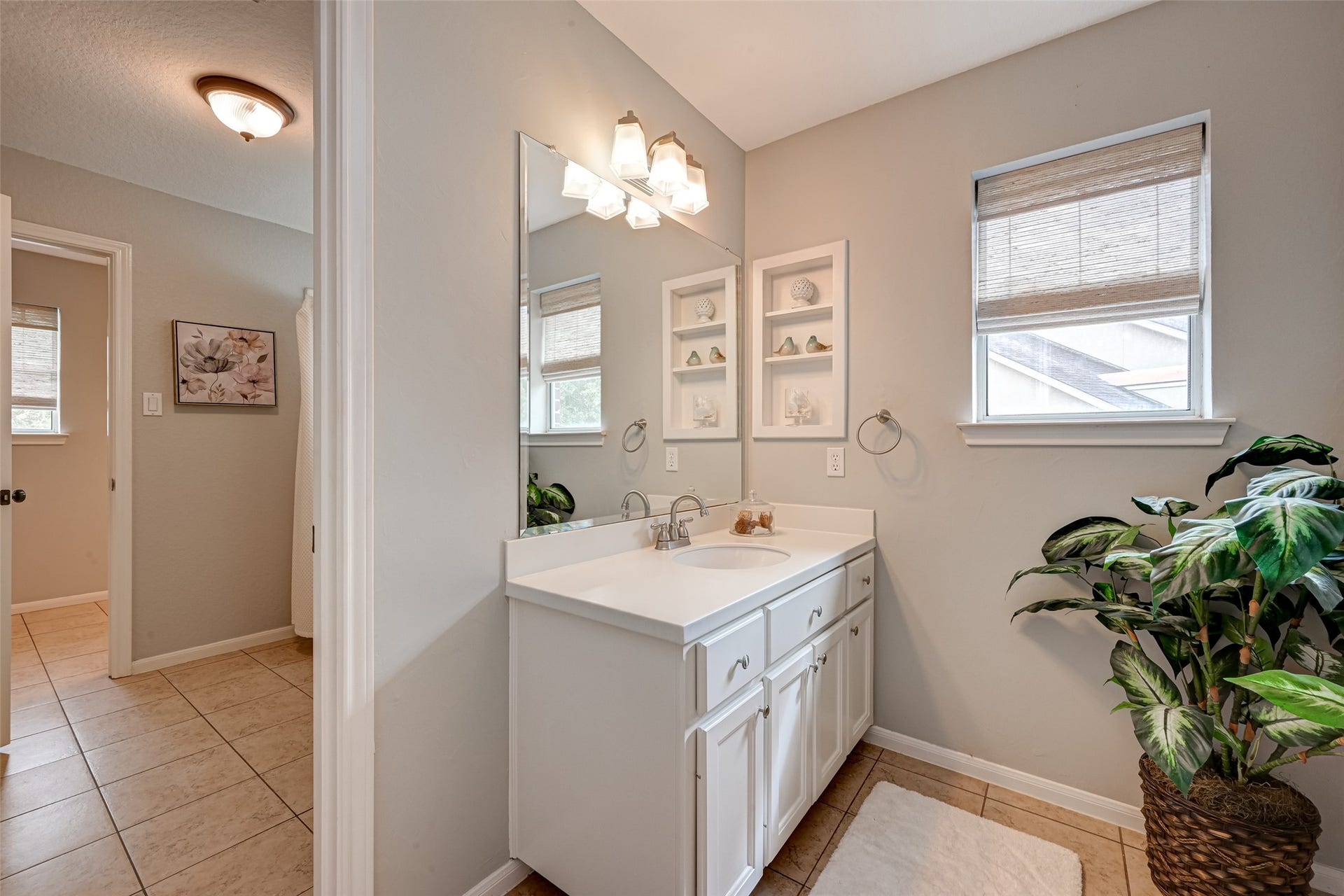 7707 Stone Arbor Drive, Sugar Land, TX 77479 A smart Jack & Jill arrangement! This second sink vanity serves Bedroom #3 and also offers direct access from the upstairs hallway, making it convenient for guests using the 2nd-floor Gameroom. Features include generous counter space, cabinetry, a large mirror & natural light. The adjoining door leads to the shared tub/shower & commode area, with Bedroom #2s private vanity beyond.