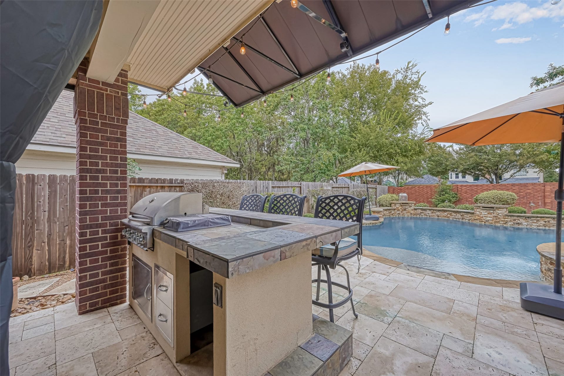 7707 Stone Arbor Drive, Sugar Land, TX 77479 Made for entertaining! The covered outdoor kitchen puts the gas grill, bar seating & swimming pool all within easy reachperfect for cookouts, pool parties or casual weekends with family & friends. Generous tiled counter space makes serving a breeze, while built-in storage keeps grilling essentials close at hand. Cook, visit & keep an eye on the poolall from one spot!